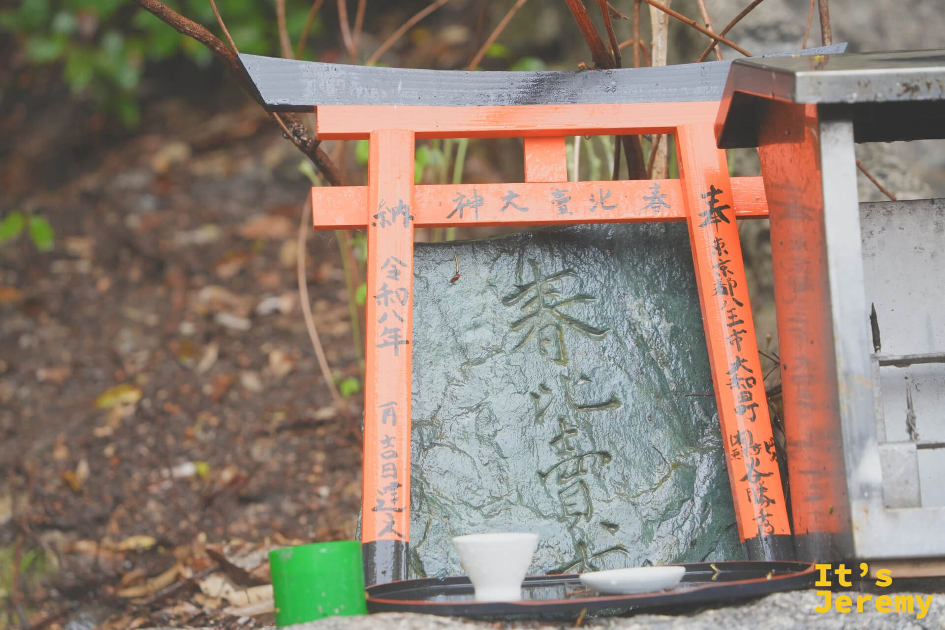 山路旁，有人在迷你鳥居供台前擺上茶碗作為供品