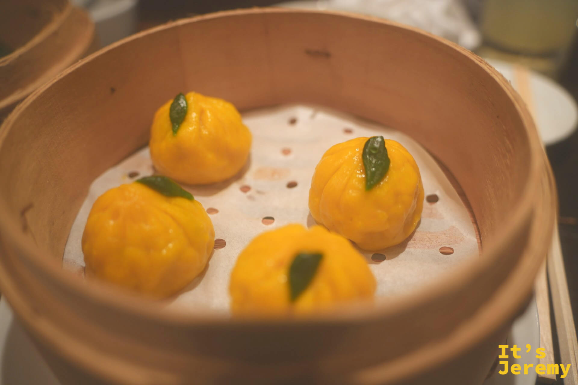 黃柚子餃子,外皮金黃飽滿,盛在蒸籠裡
