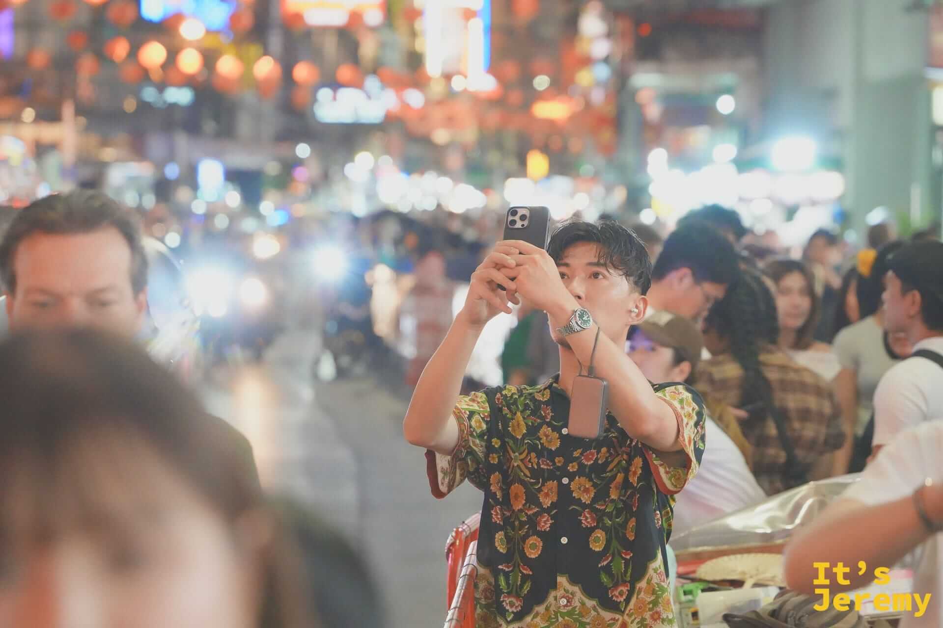另一位路人停在街邊舉起手機拍攝唐人街街景