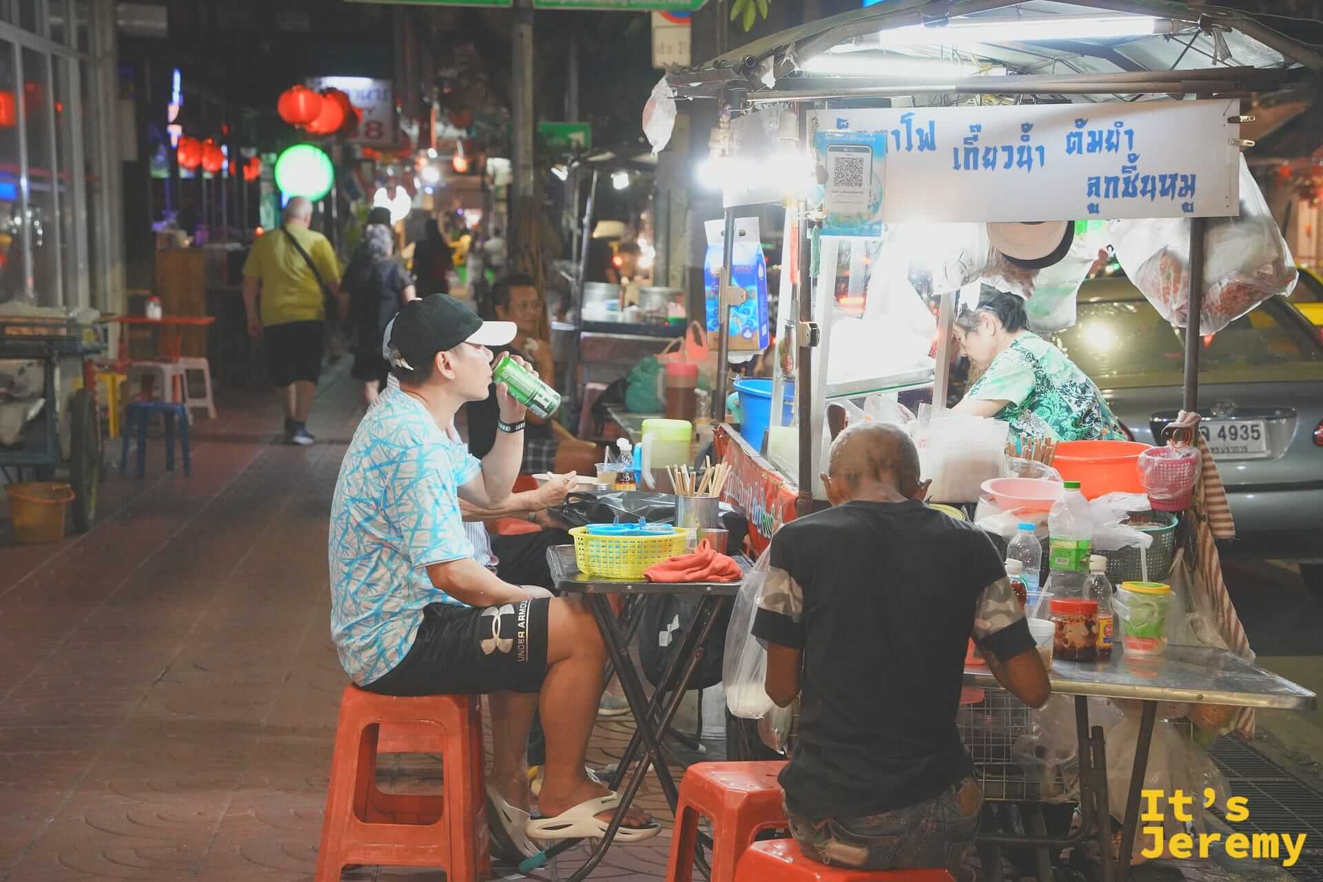 唐人街街邊小販以及坐在攤位前用餐的客人