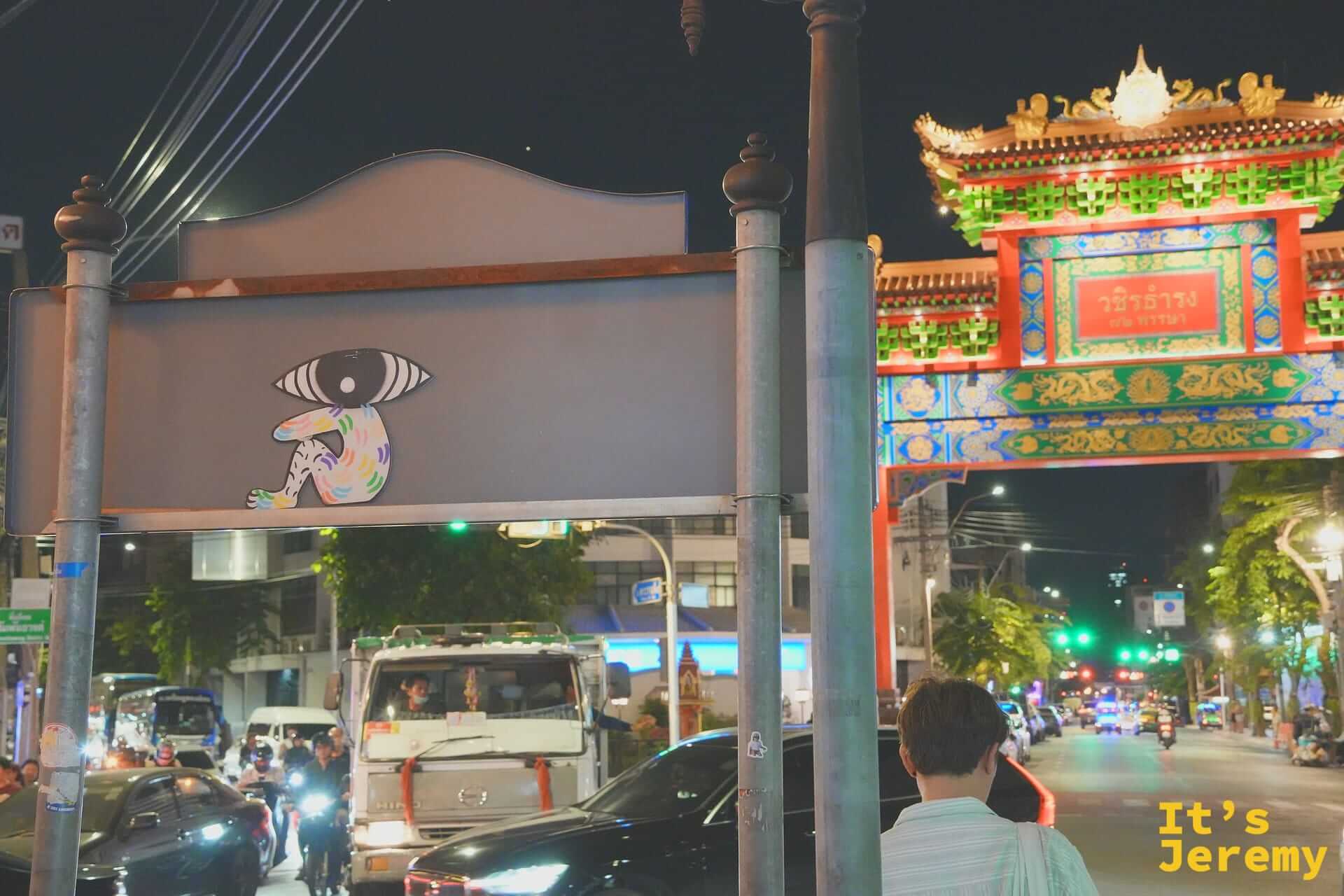 唐人街上路牌後的塗鴉貼紙與遠方聖壽無疆牌坊