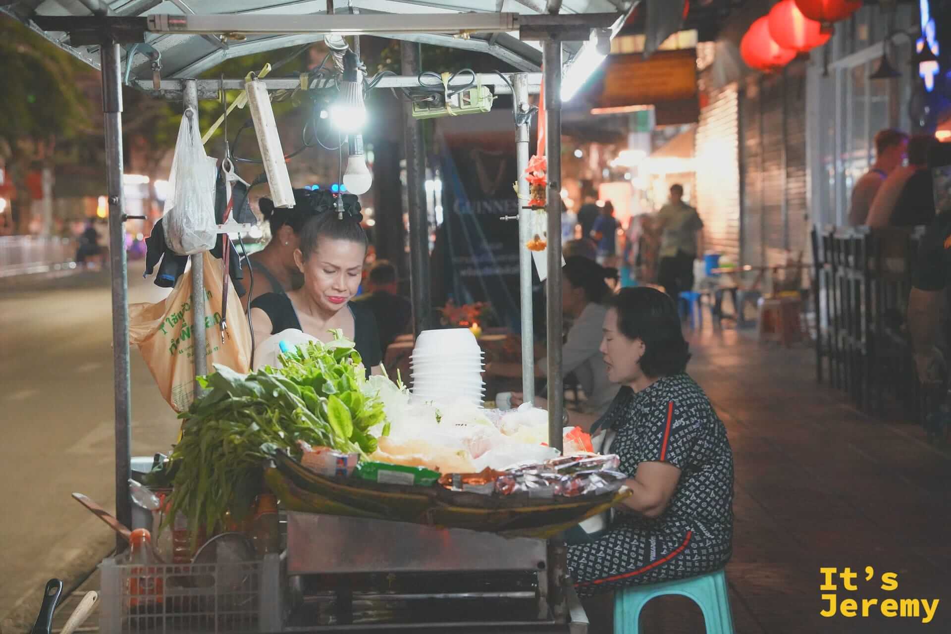 唐人街街邊小販與正在低頭專心吃飯的食客