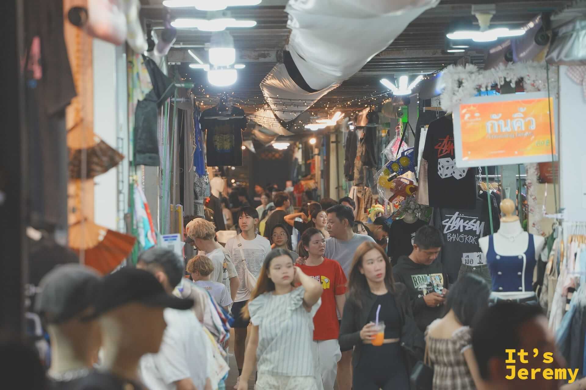 夜市中央走道的人潮與兩側鐵皮屋頂攤位