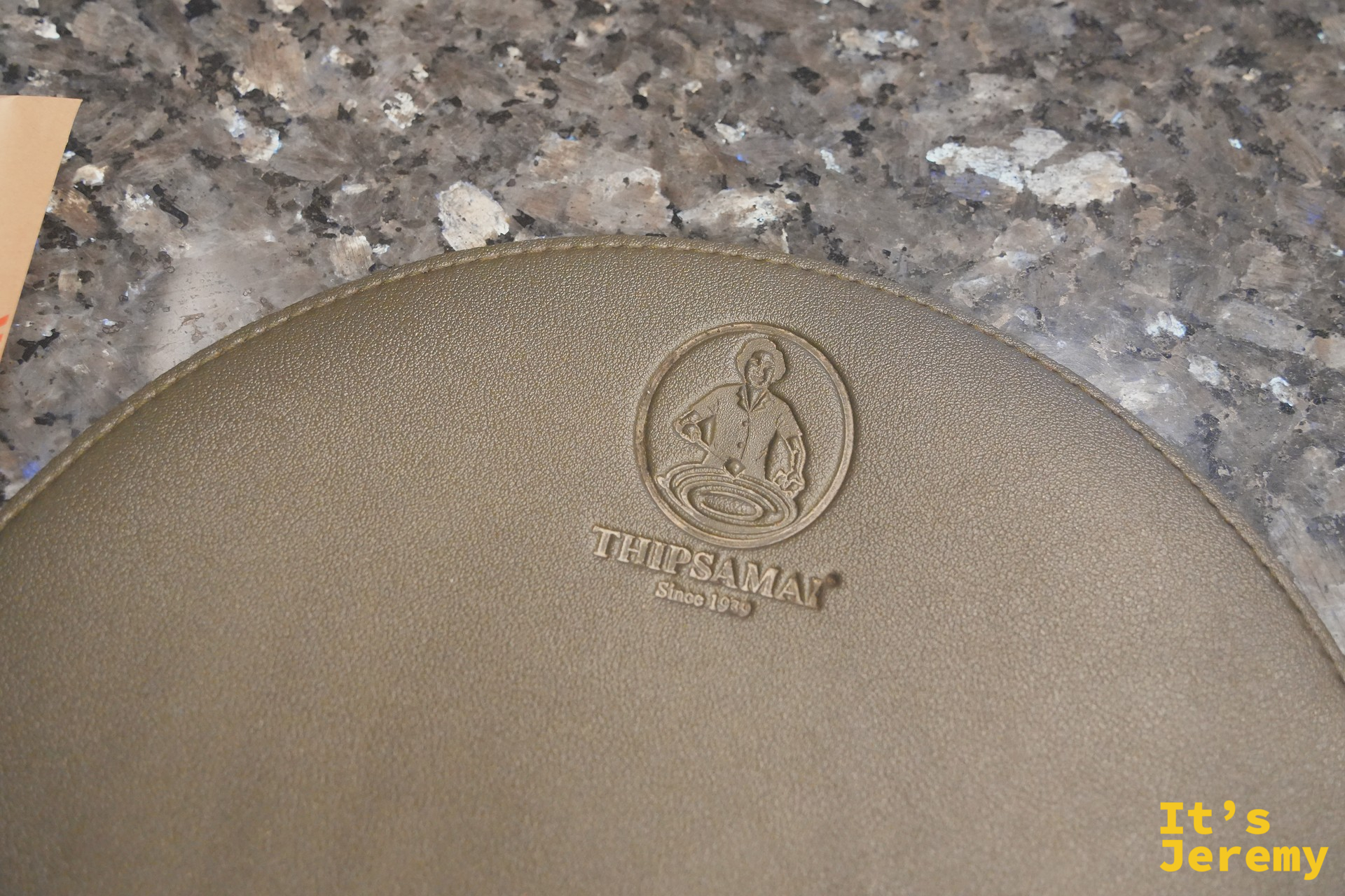 Thipsamai 印著店家 logo 的襯盤紙墊細節