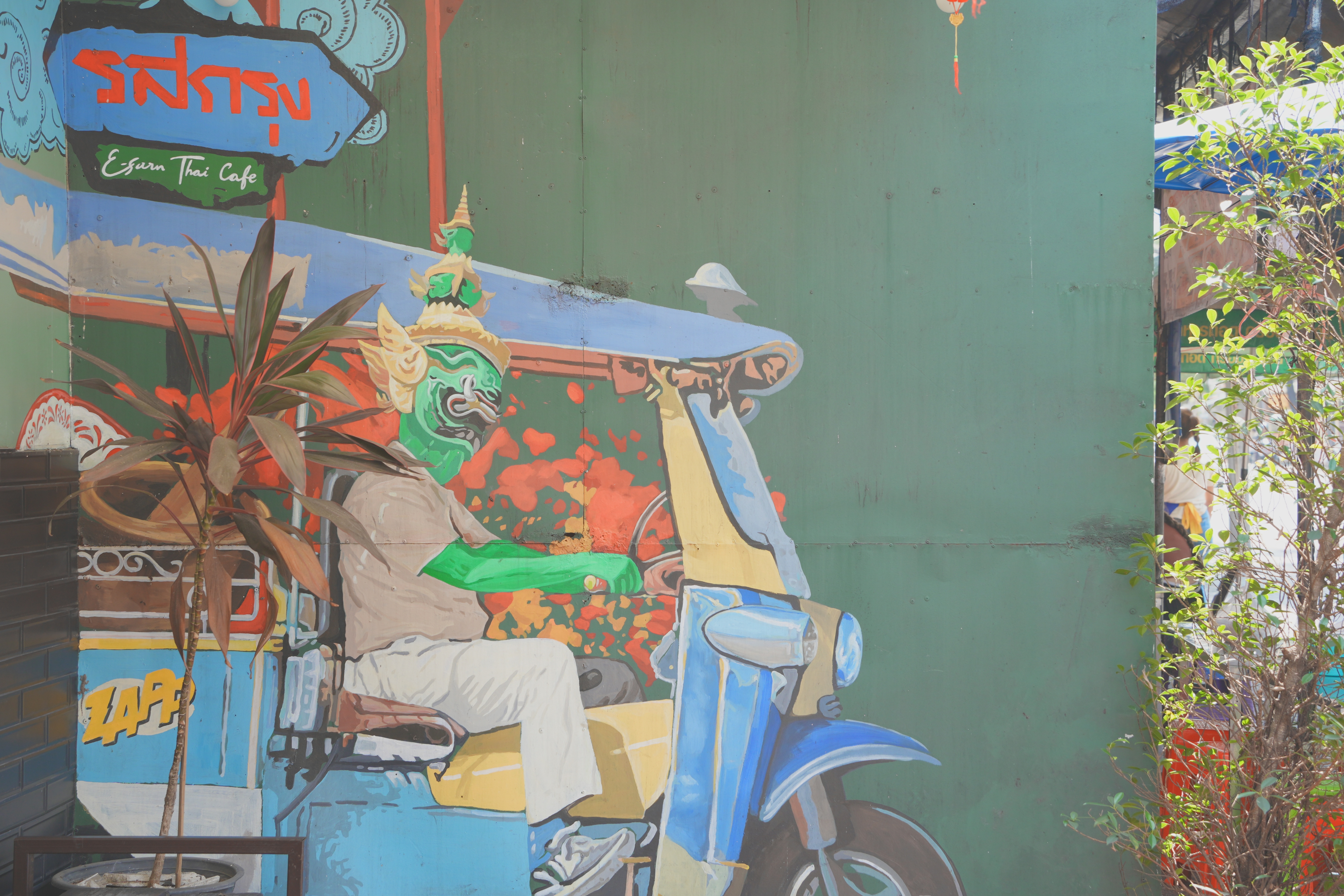 Edsuk Thai Café 綠色牆面塗鴉：戴泰拳面具的神話人物騎 tuk-tuk