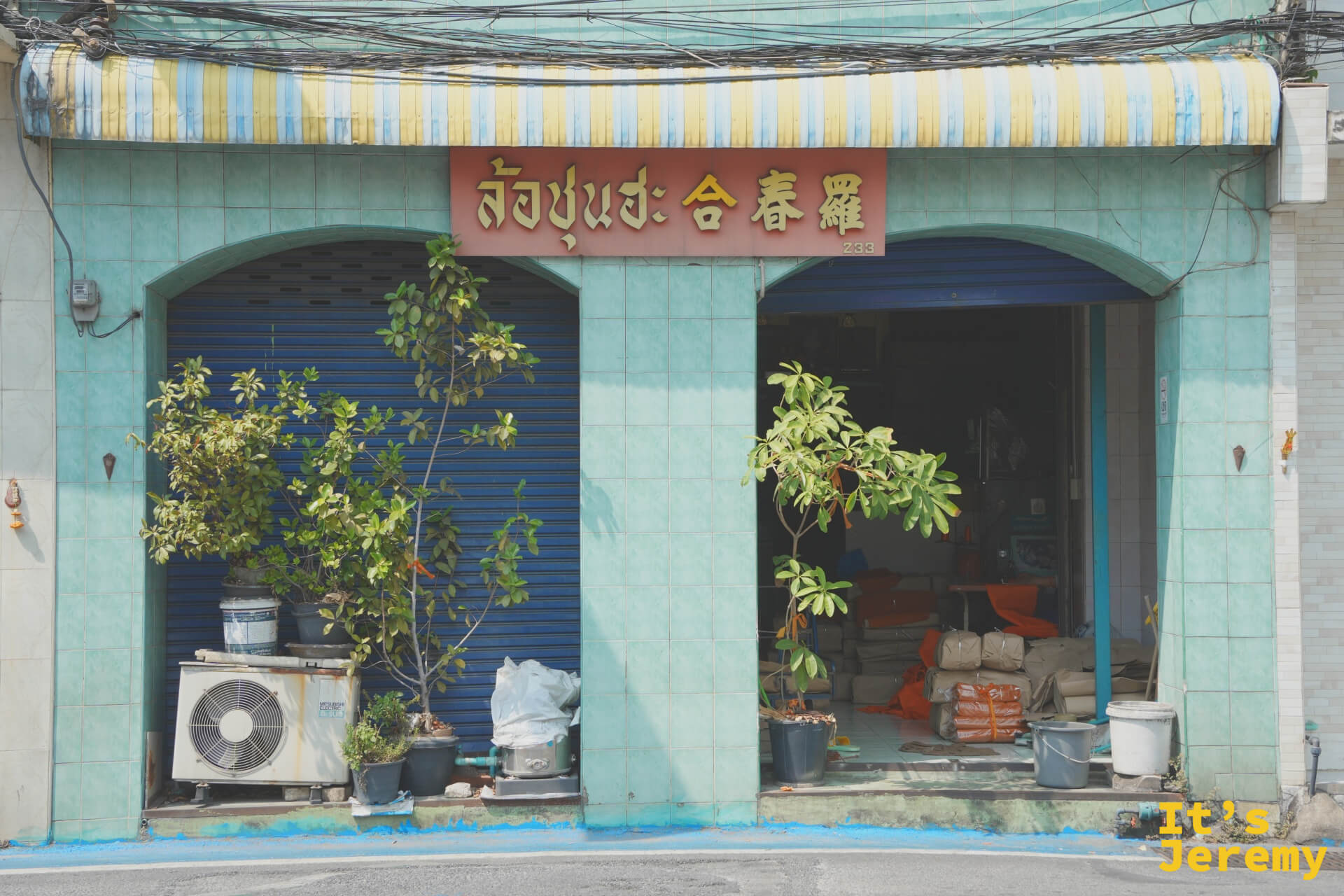 薄荷綠老店面與紅底金字的「合春羅」中泰雙語招牌