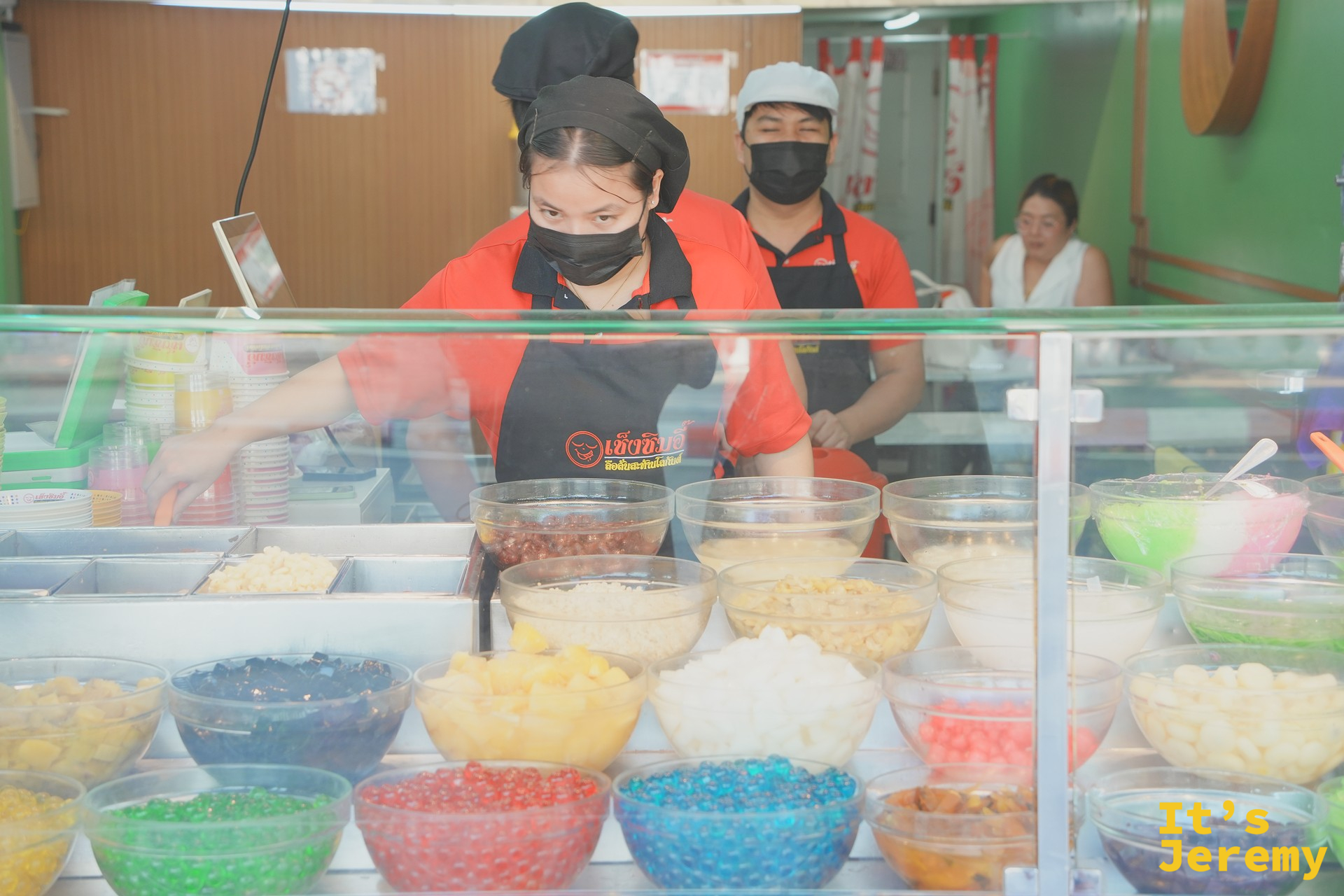 店員在配料盆後方準備食材的瞬間