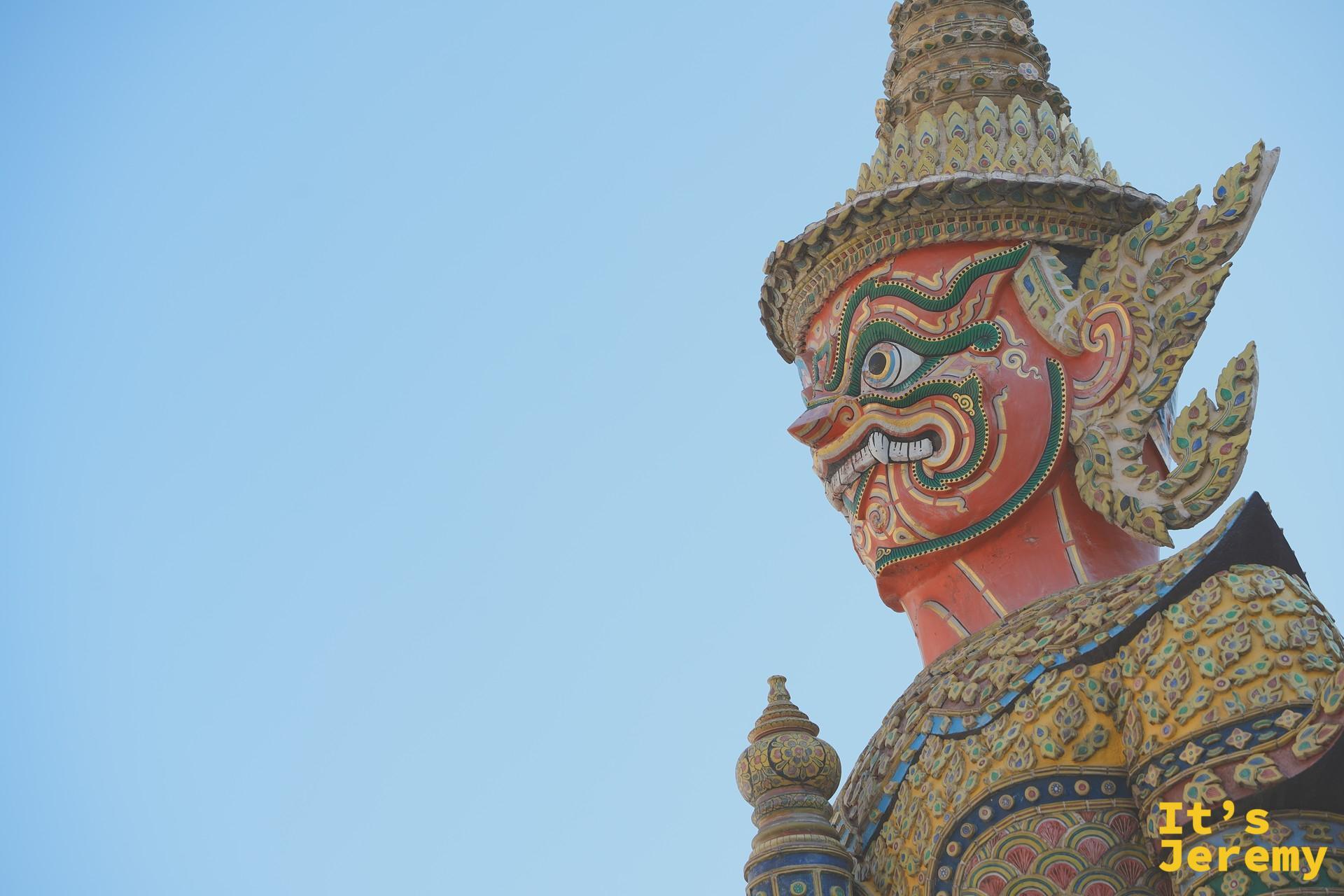 紅臉 Yaksha 巨像特寫，戴尖頂金冠、表情凶猛