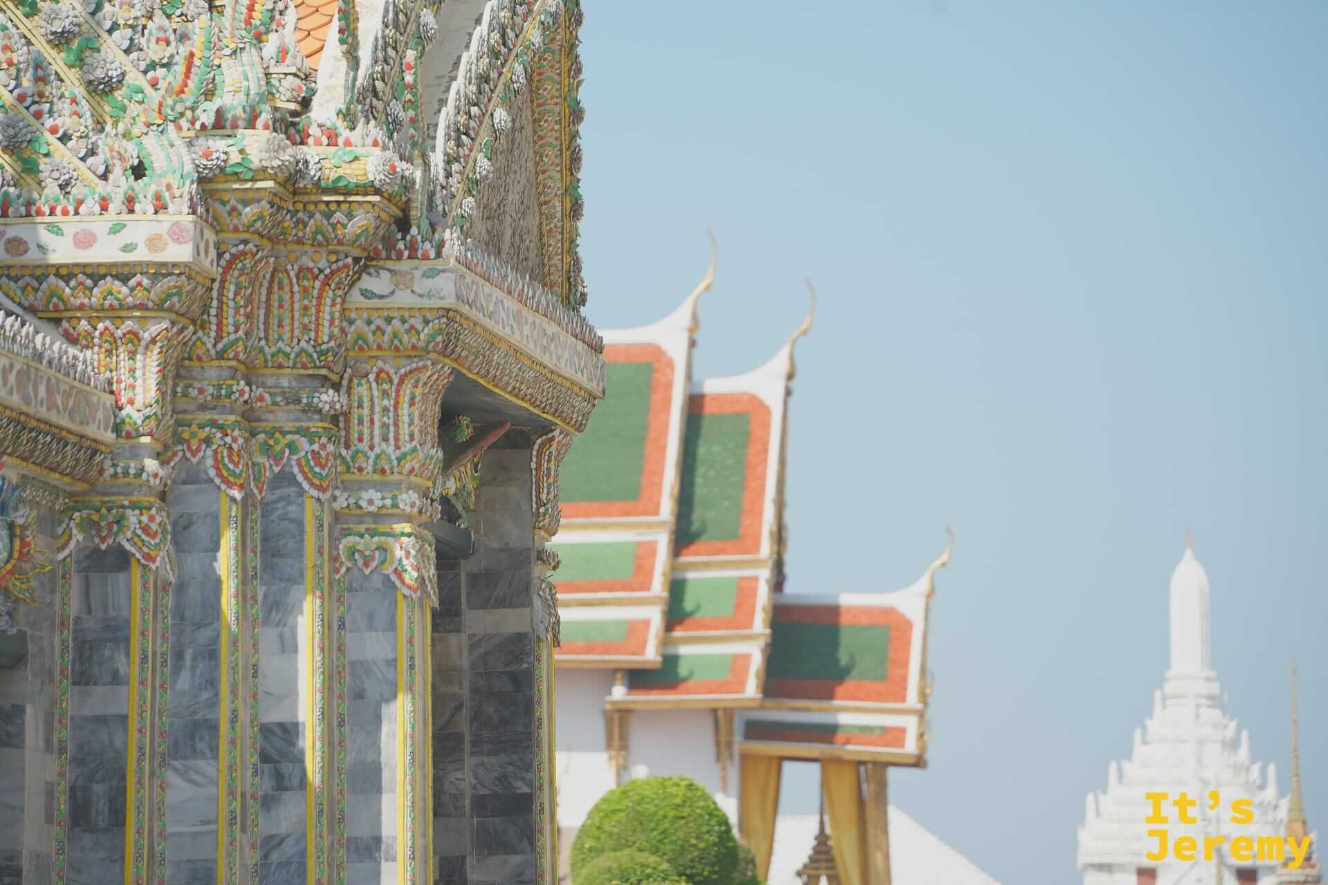 中宮區建築側面，彩色山牆裝飾與遠方白色 Prasat 塔