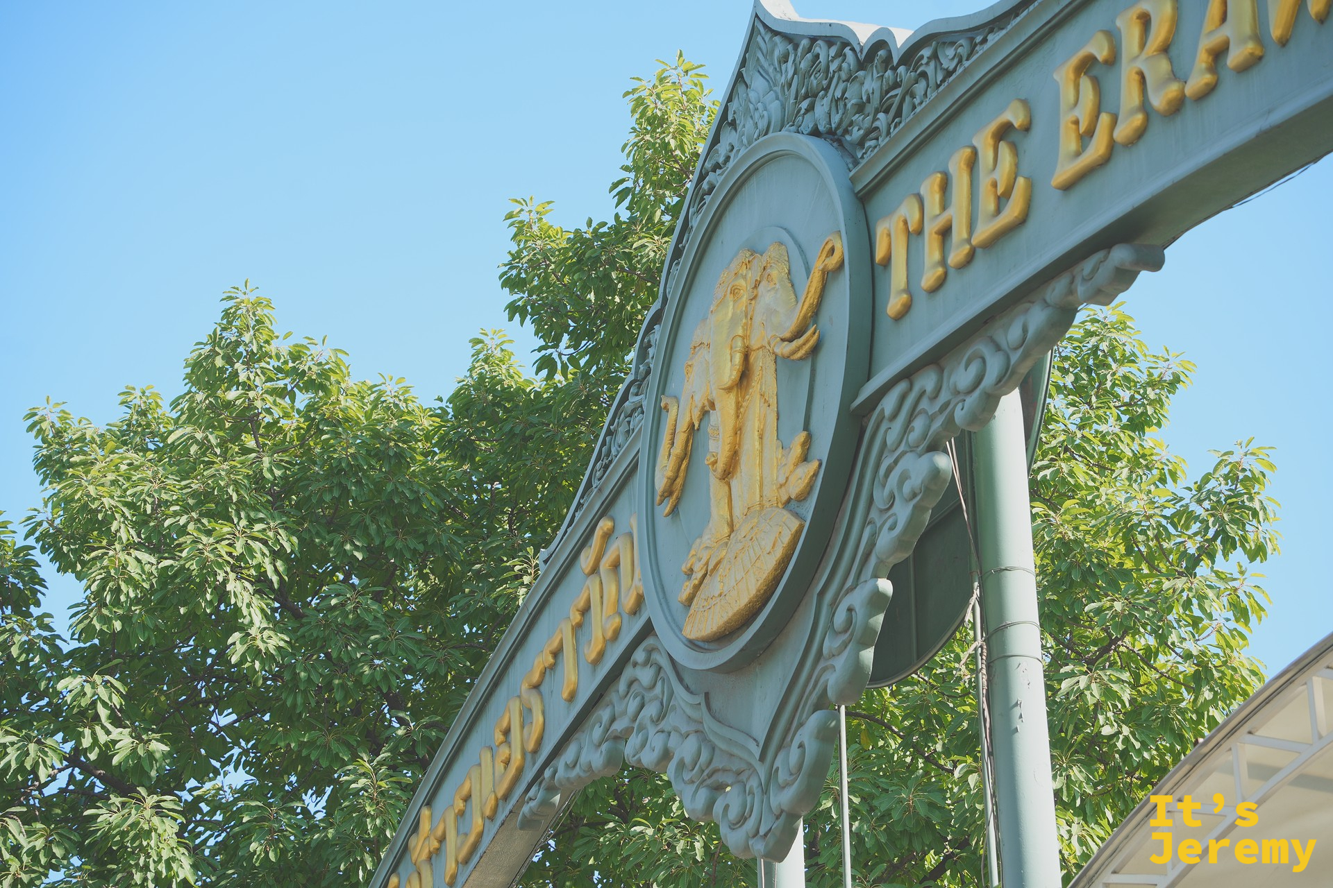 博物館入口大牌坊特寫，金色 The Erawan 字樣與洛可可雕飾