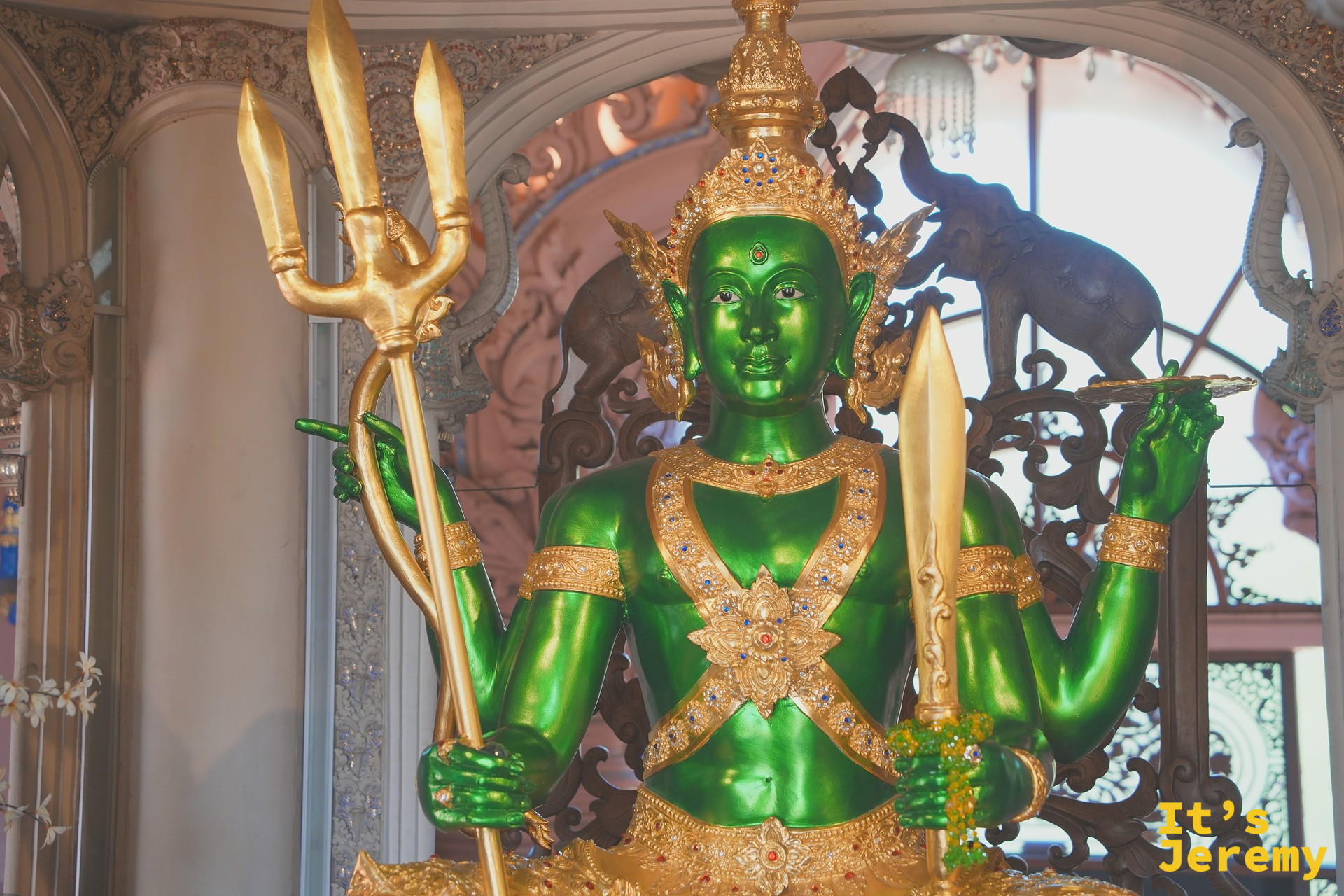 象腹正中央的翡翠綠四臂神祇雕像，背後是印度教神話浮雕