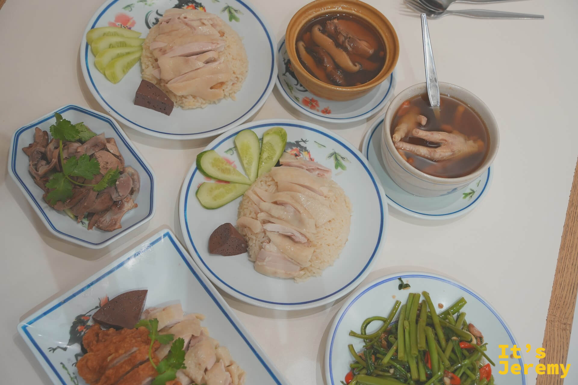 紅大哥兩盤海南雞飯上桌俯拍,配湯品、雞雜與空心菜