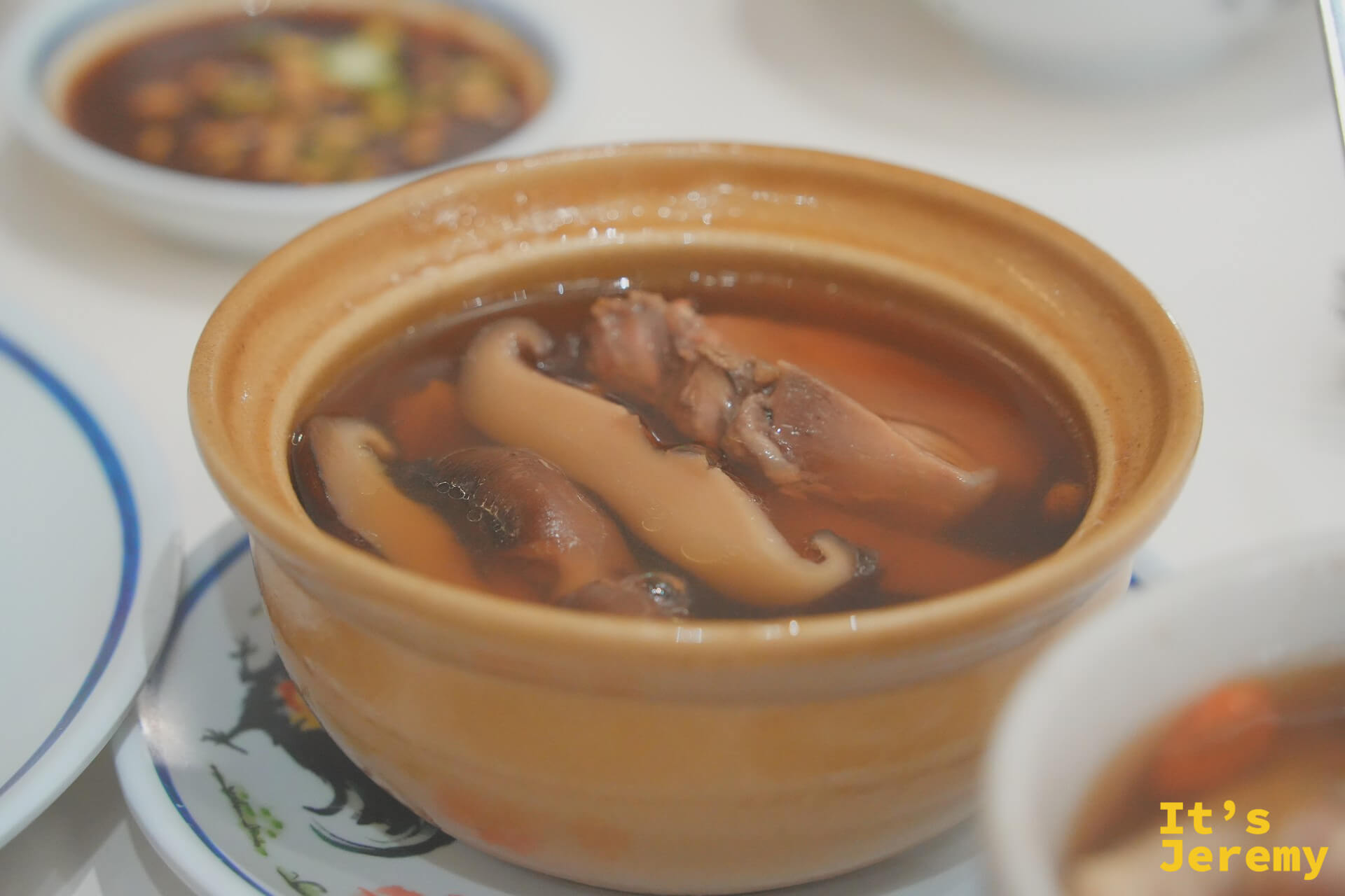 紅大哥香菇燉雞湯特寫:黃色小砂鍋裡的肥厚香菇與雞肉、湯色琥珀