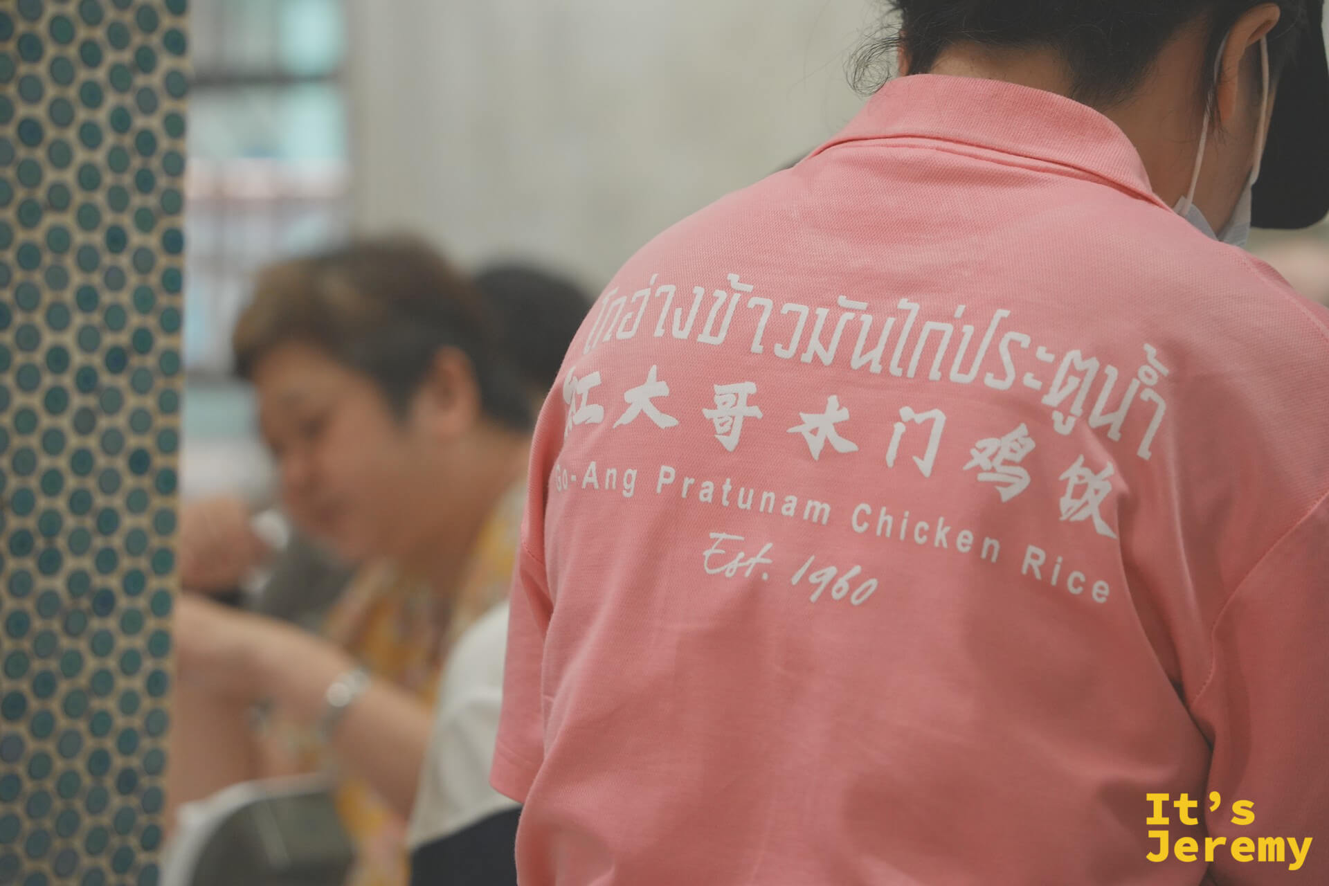 紅大哥粉紅制服員工背面:泰中英三語店名與 Est. 1960 字樣清晰可見