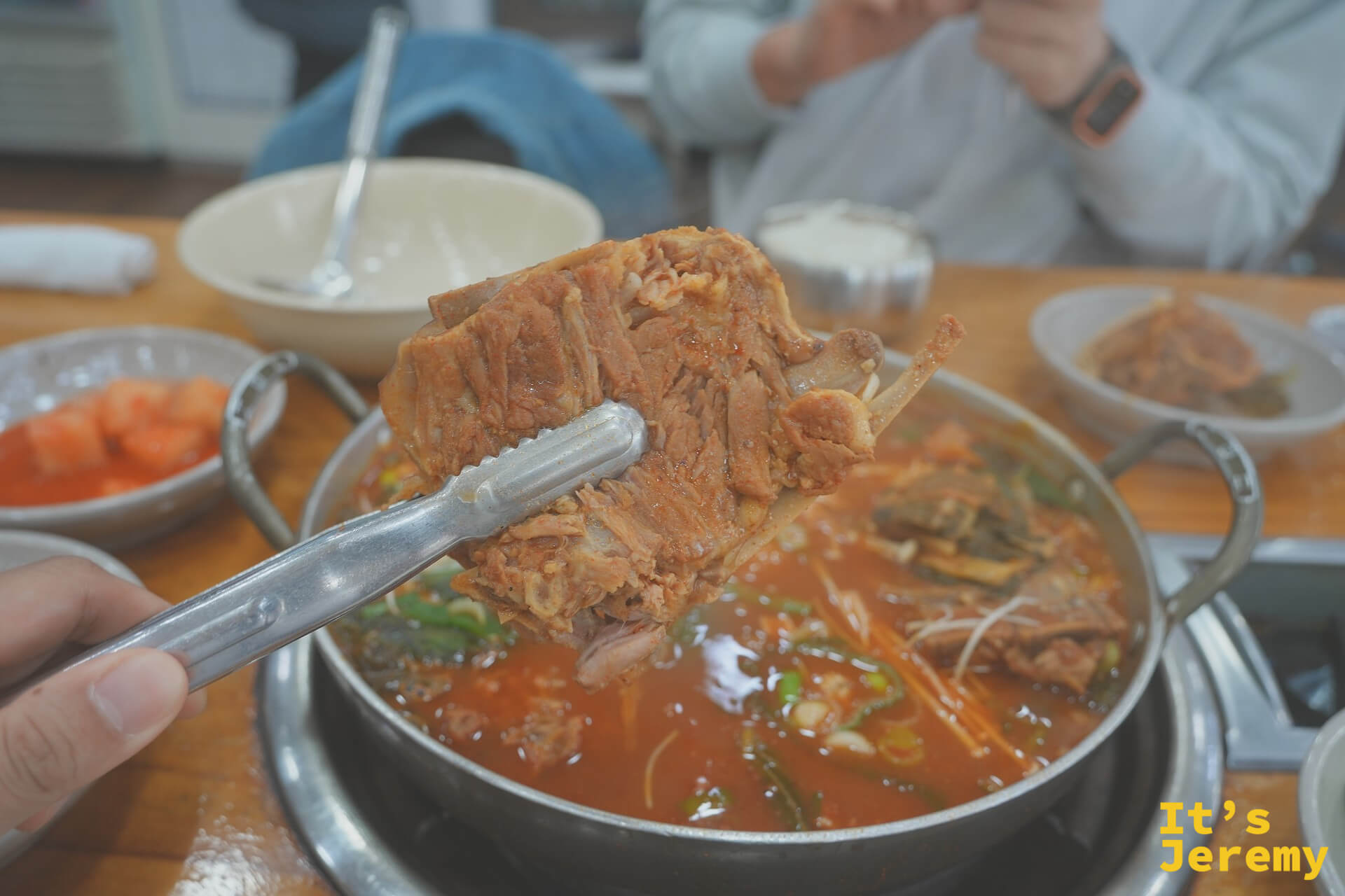 用夾子夾起豬骨肋排，骨肉分離的軟嫩狀態一目了然