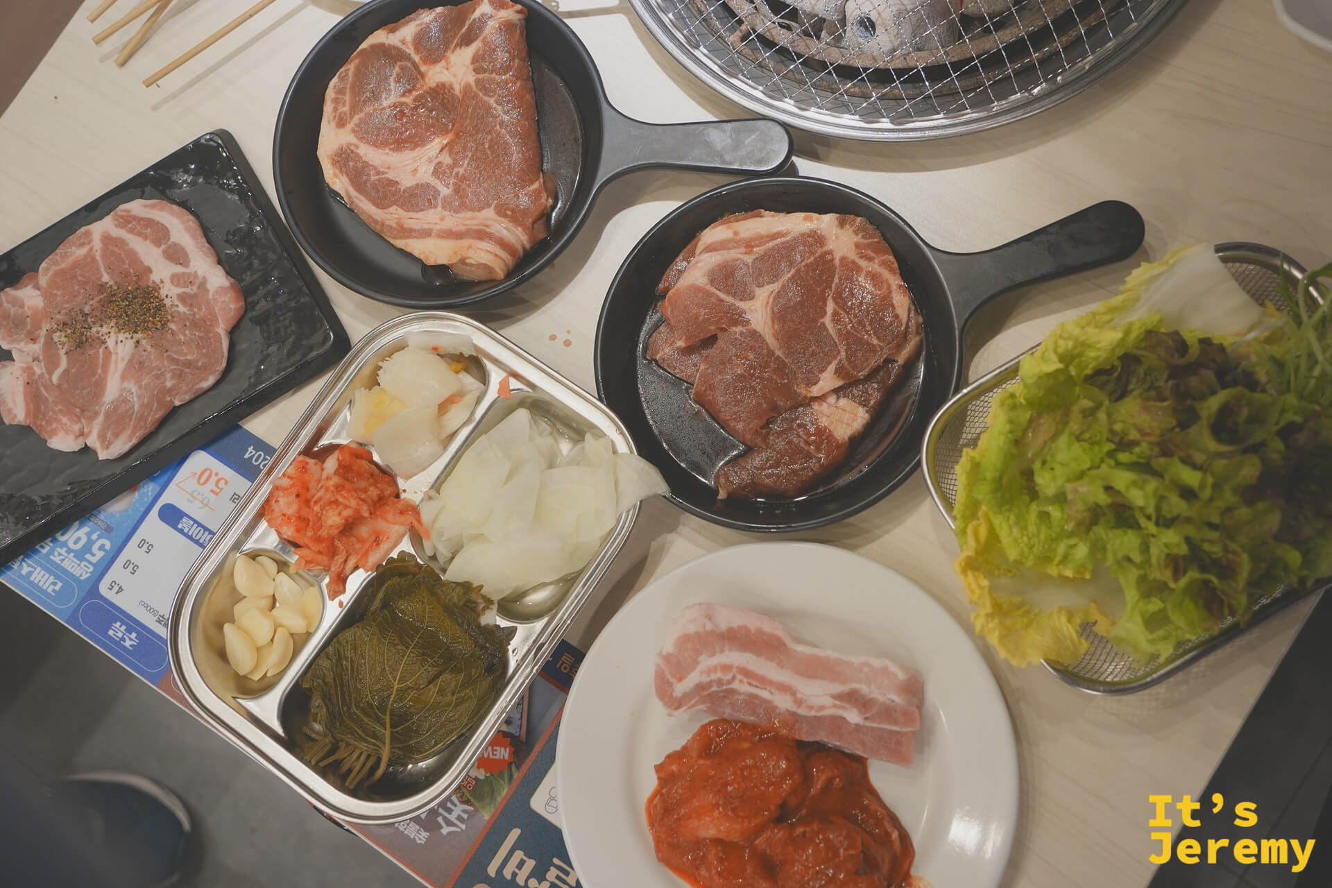 桌上一次送來多種肉品:삼겹살、목살與돼지갈비,配上生菜、大蒜與泡菜小菜盒
