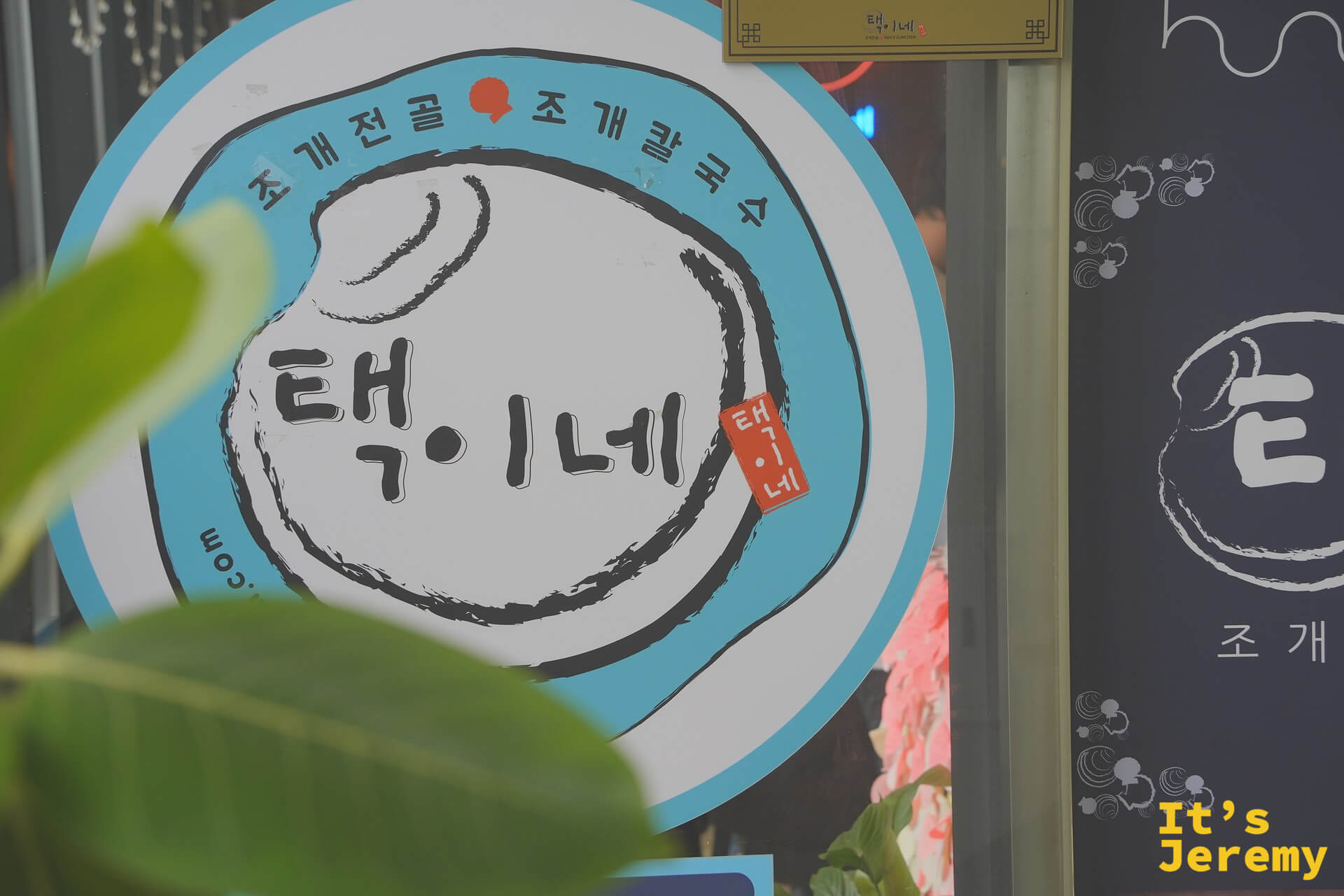 澤家貝殼蒸鍋招牌,藍色圓形 logo 上寫著 택이네,貝殼火鍋與貝殼刀削麵