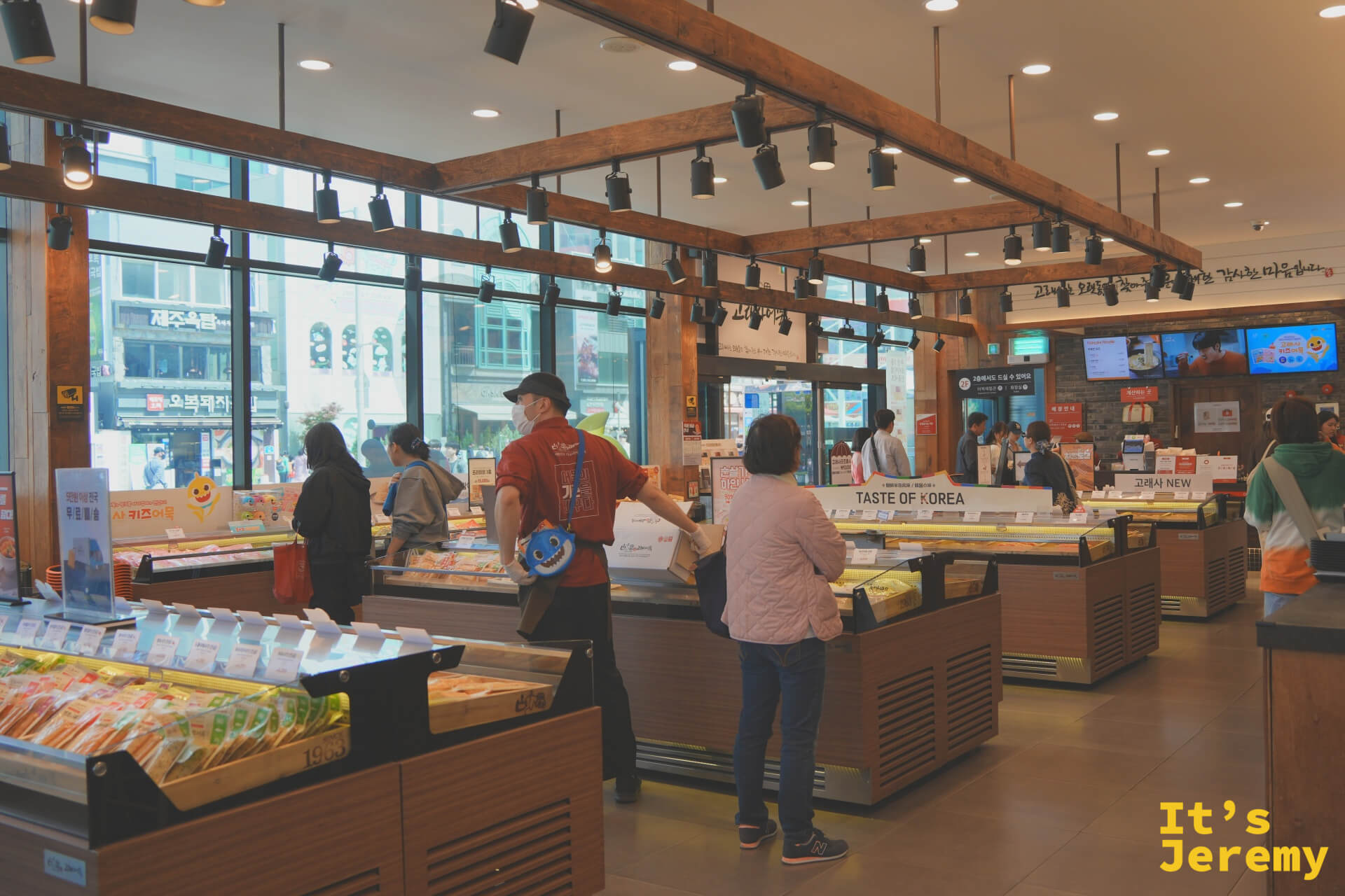 古來思魚板海雲台店室內全景，木質樑柱、暖光陳列台與多個魚板展示區