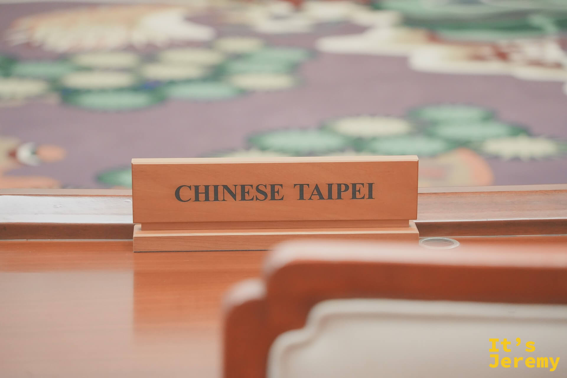 APEC 會議廳圓桌近景，刺繡地毯細節清晰，CHINESE TAIPEI 名牌特寫