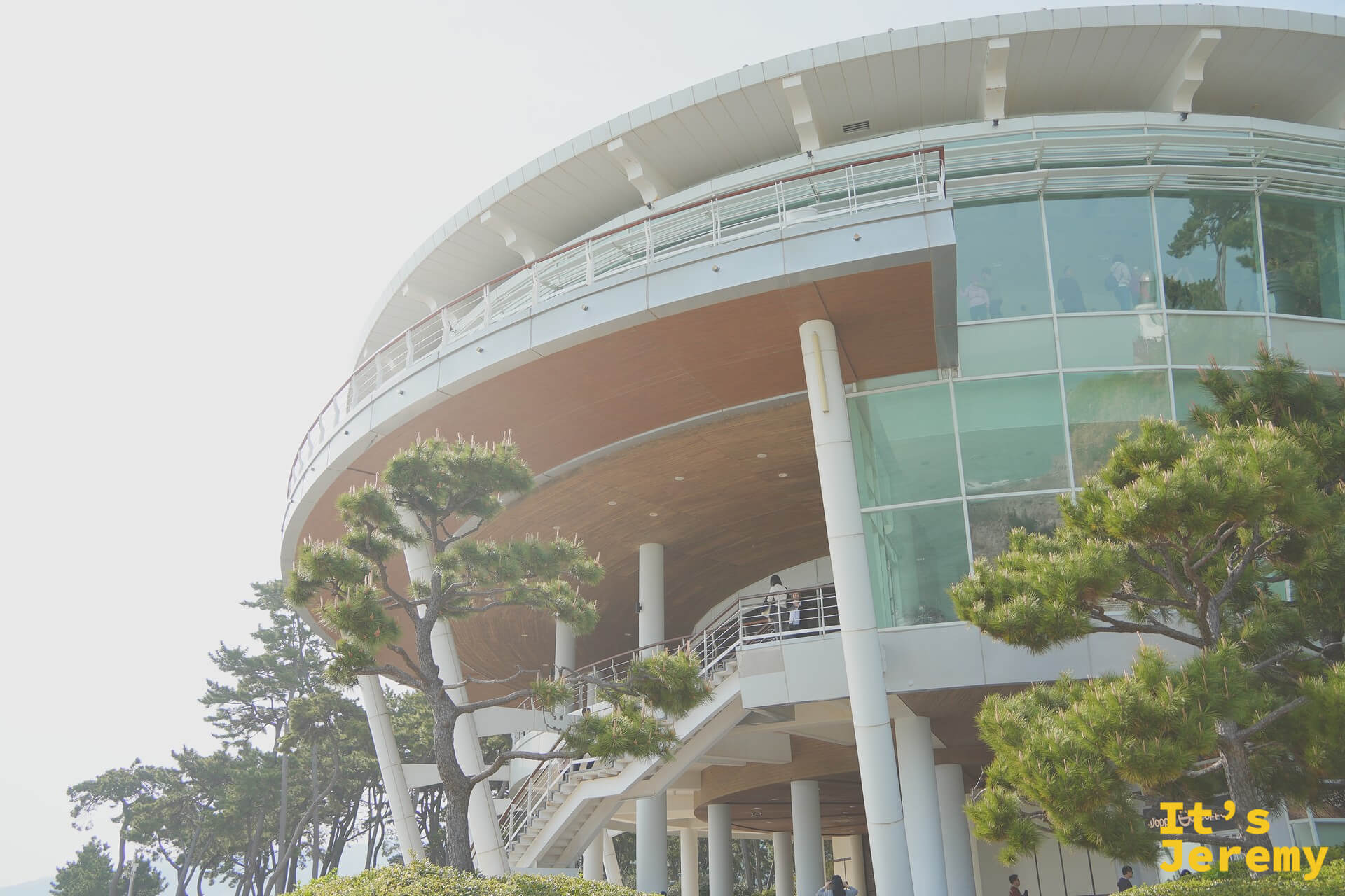 누리마루 APEC 하우스 現代玻璃建築外觀，圓弧形的屋頂曲線與周圍松樹相互呼應