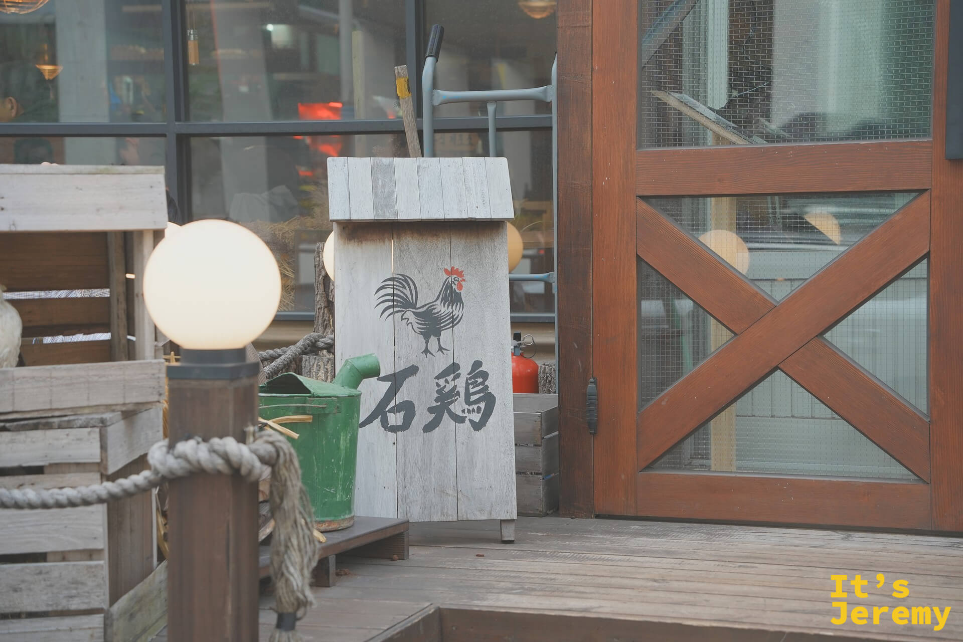 店門口以「石雞」漢字刻在木牌上,搭配粗麻繩與木箱的農場風陳設