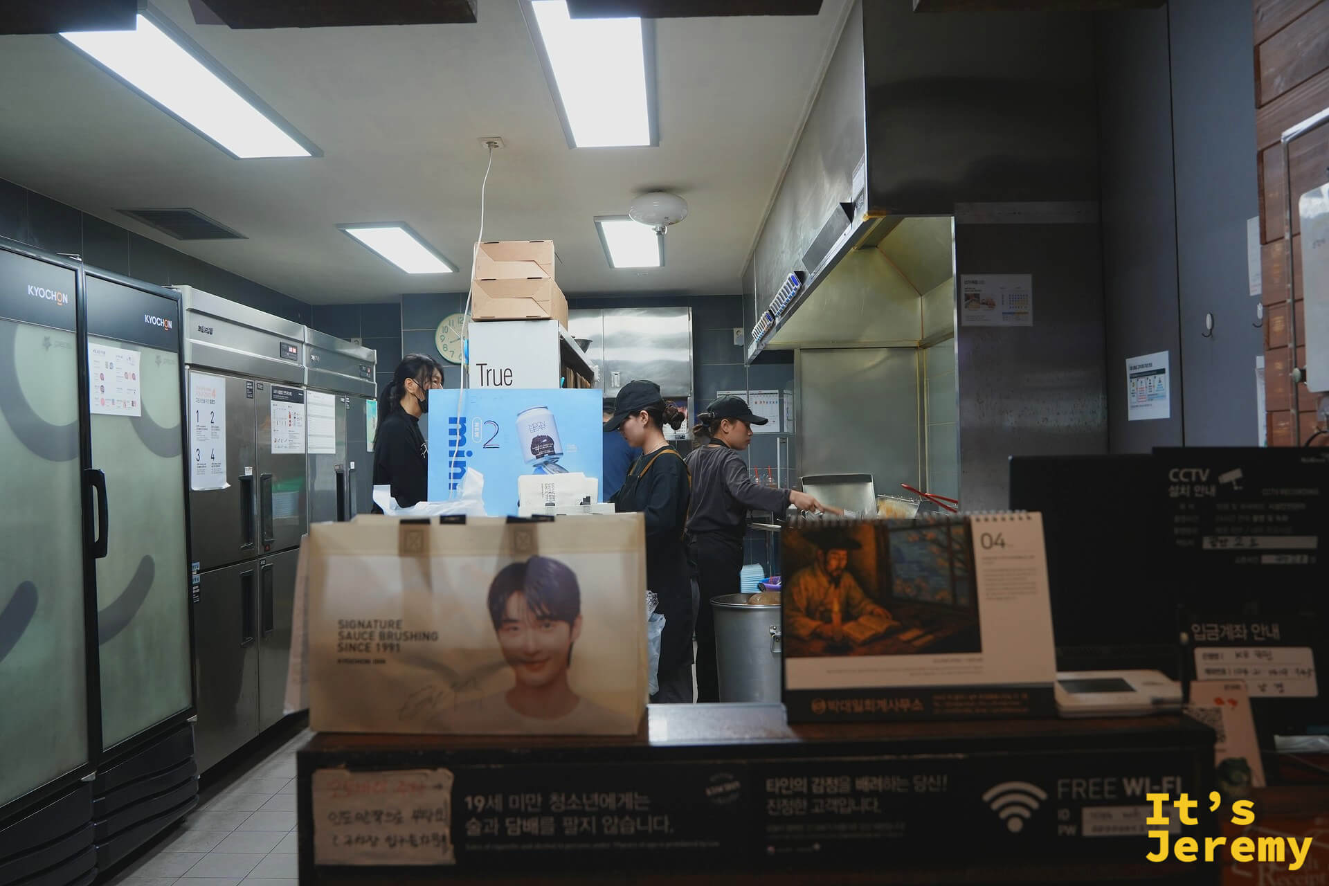 교촌廚房備餐中,桌上的白色外帶袋印著代言人的大頭照——提著這個袋子走出去,回頭率有點高