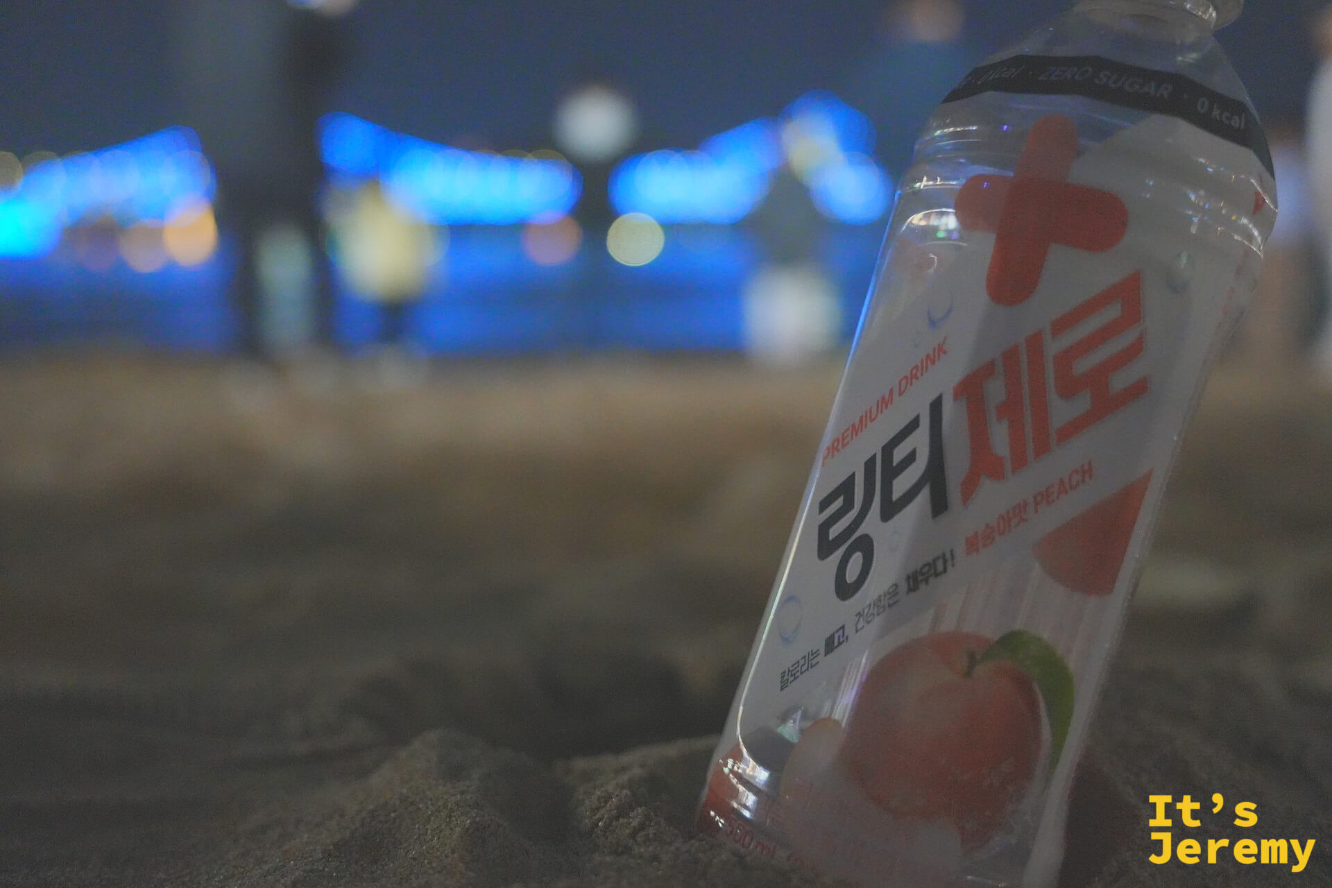 링티 제로插在廣安里沙灘上，背後是廣安大橋藍色燈光