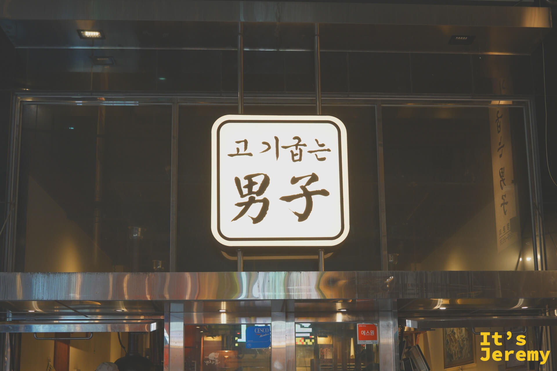 고기굽는男子 男子烤肉招牌，黑底白字在夜色中靜靜發光
