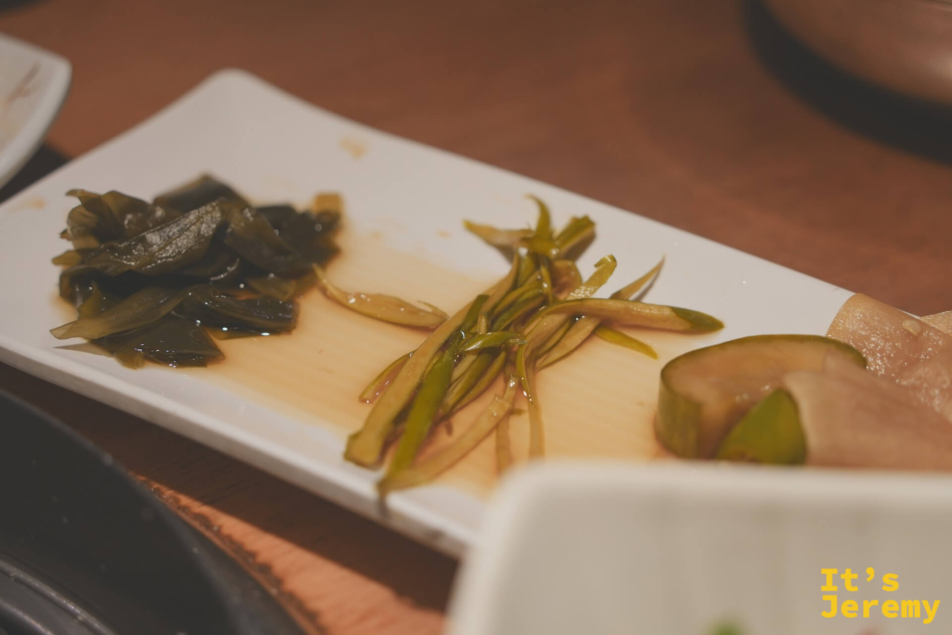 三種醃漬小菜拼盤：海帶、蔥絲與蘿蔔，清爽解膩，是吃烤肉時最佳的口感轉換器