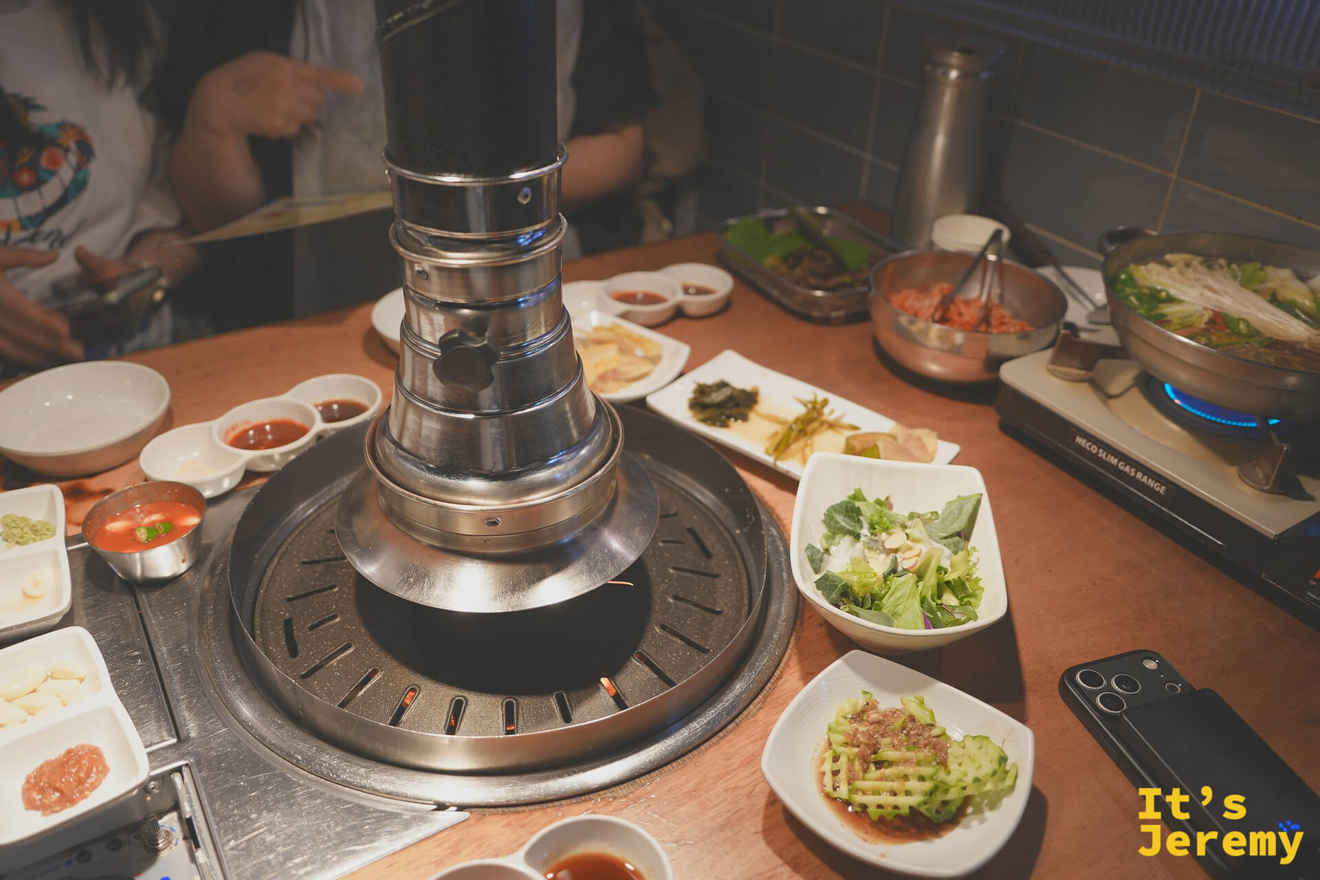 滿桌的前菜小碟：生菜沙拉、醃漬海帶、涼拌青蔥、醋味黃瓜，配色清新，整桌從一開始就有儀式感