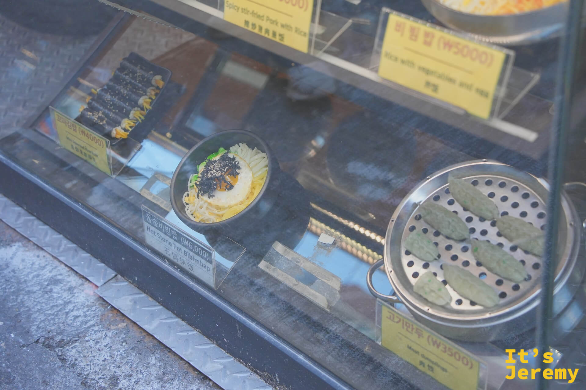 展示櫃下層可見꼬마김밥、돌솥비빔밥和고기만두的模型,一目了然