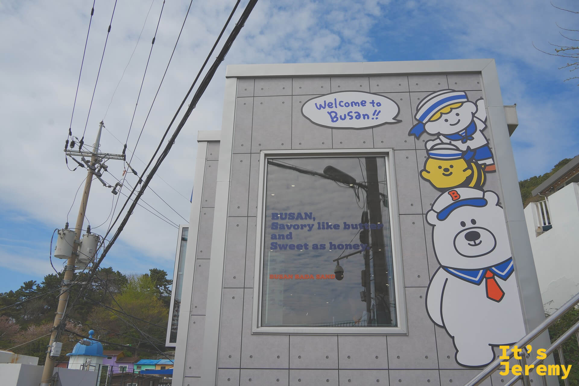 Busan Bada Sand 店外，BOOBA 熊吉祥物角色和「Welcome to Busan!!」標語