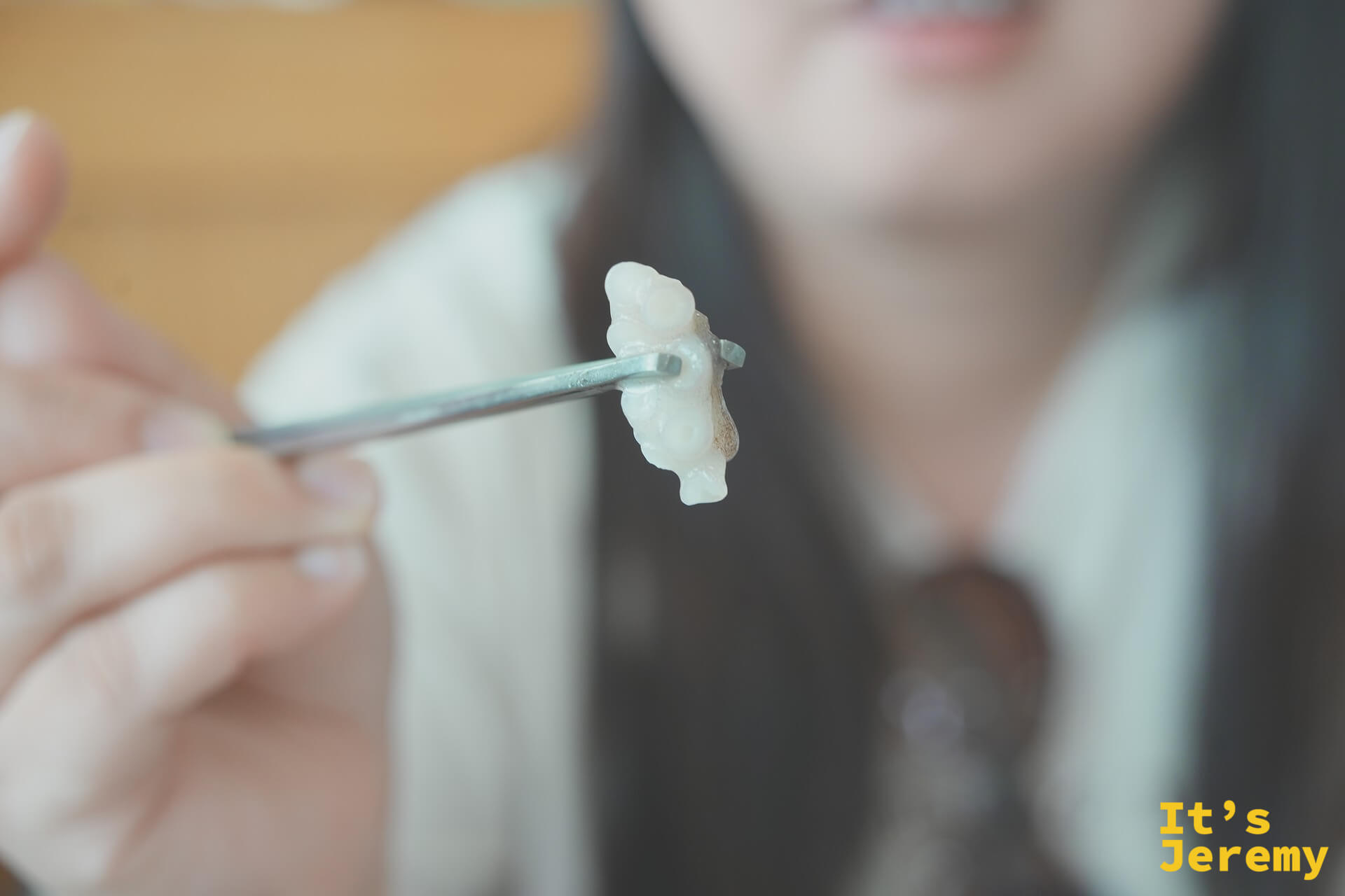 用筷子夾起一塊半透明的生章魚