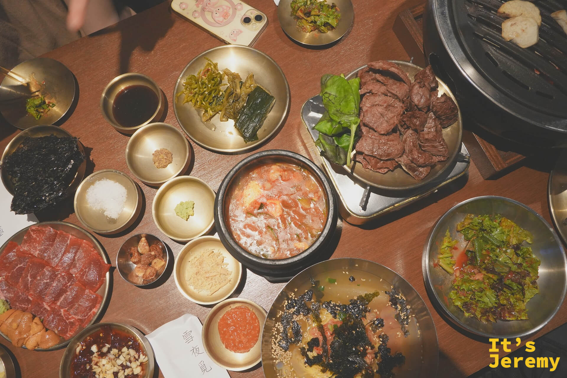 俯拍整桌：生肉盤、嫩豆腐鍋、烤好的肉、冰麵、各式小菜同時登場