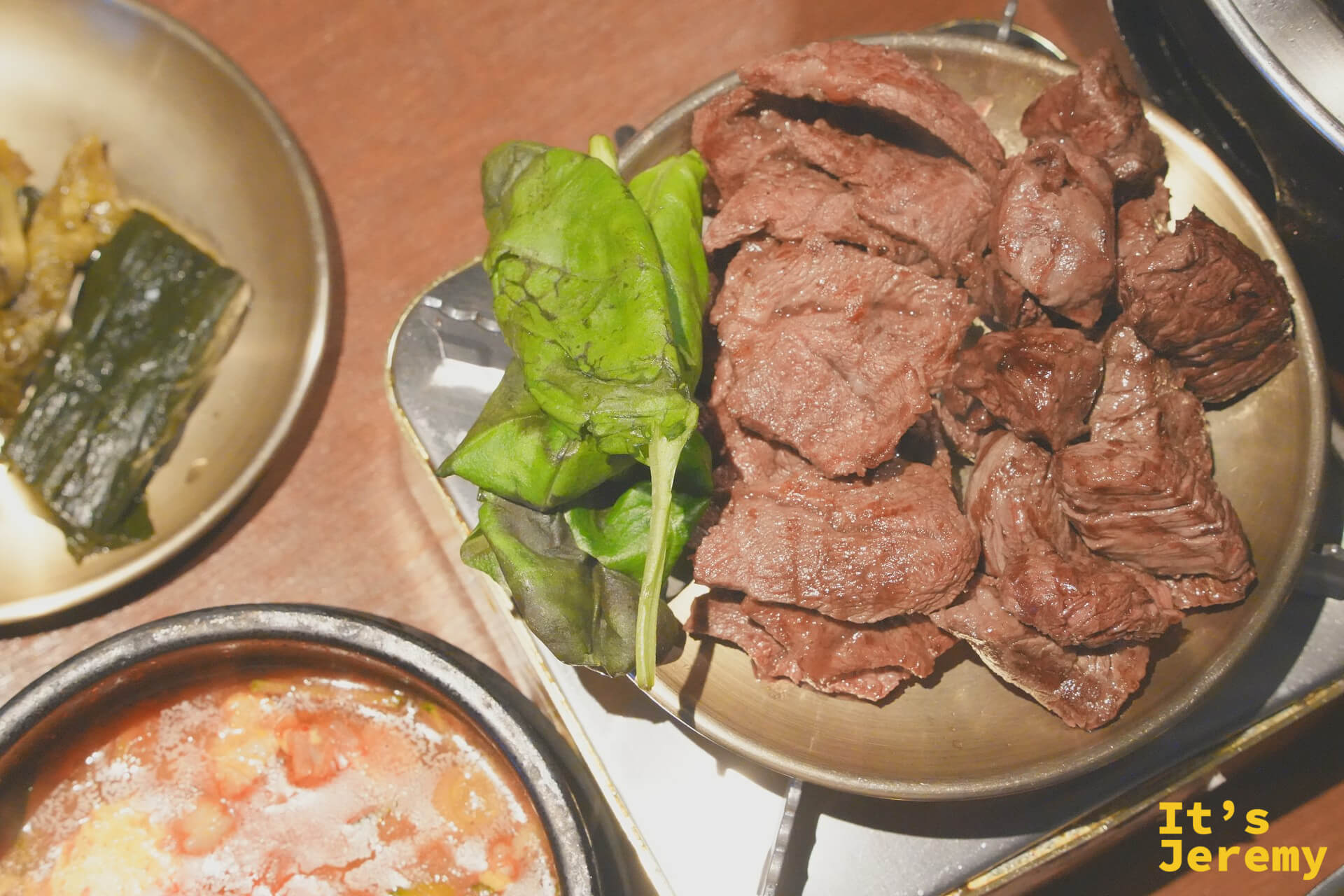 烤好的韓牛移至備料盤，搭配芝麻葉，旁邊是仍在滾的순두부