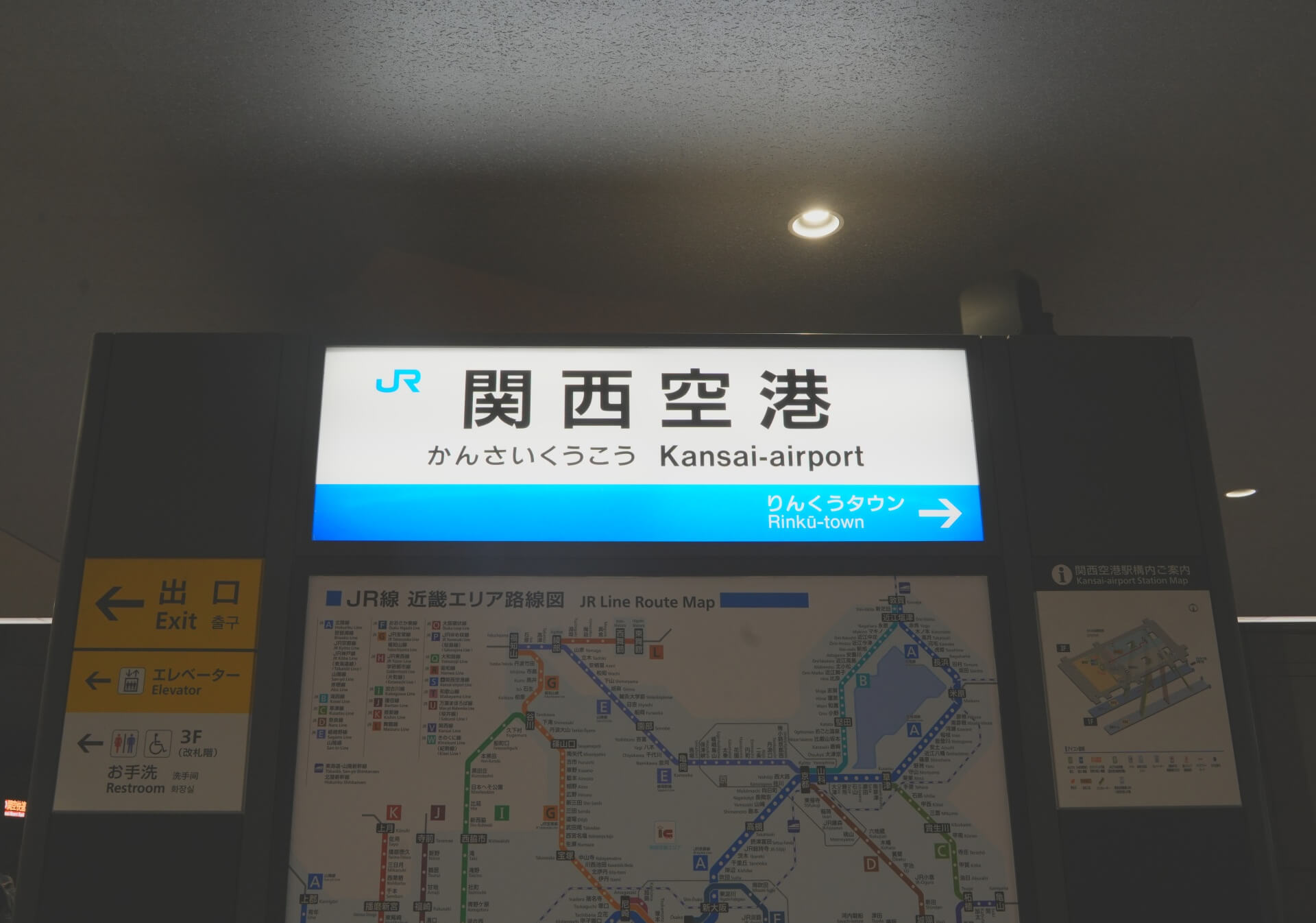 JR 関西空港站站名牌，「関西空港 Kansai-airport」白底藍字清晰標示，下方附近畿路線圖
