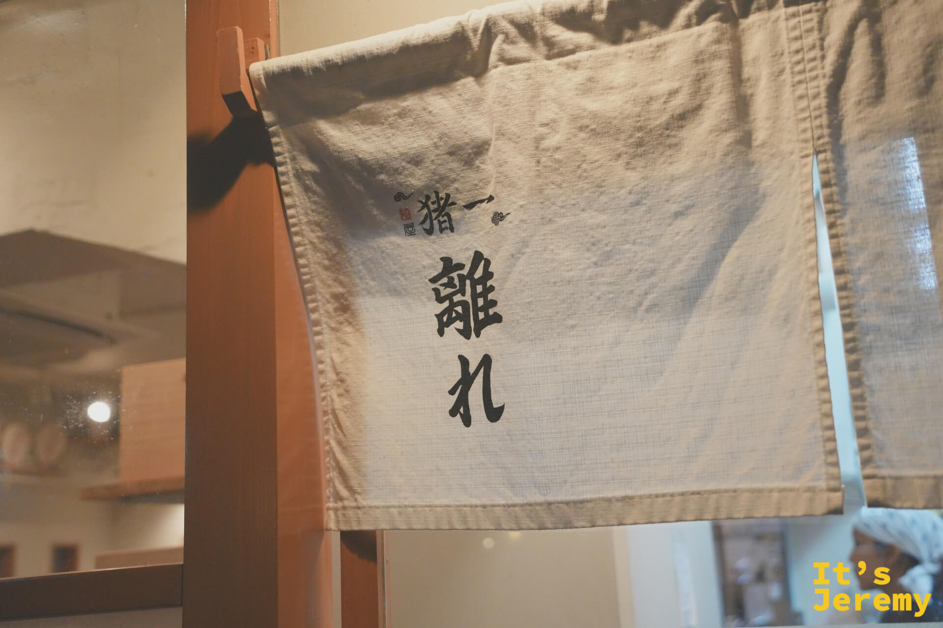 麺屋猪一入口的暖簾，墨字寫著猪一離れ