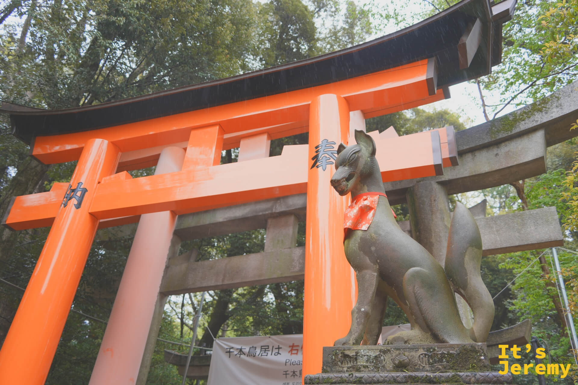 千本鳥居入口，石狐像守在側邊，告示牌寫著鳥居的意義