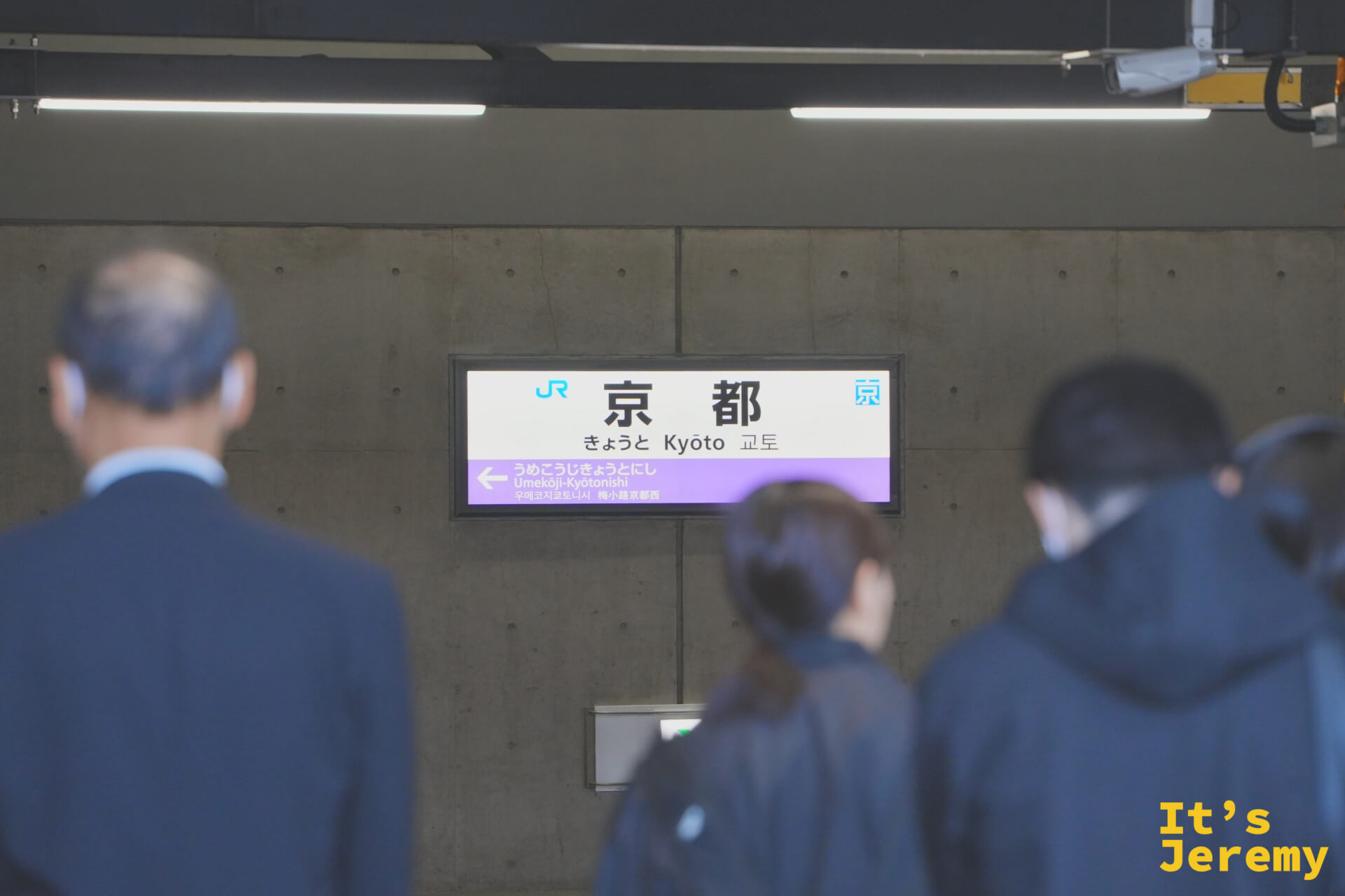 JR京都駅の駅名標と旅客の後ろ姿
