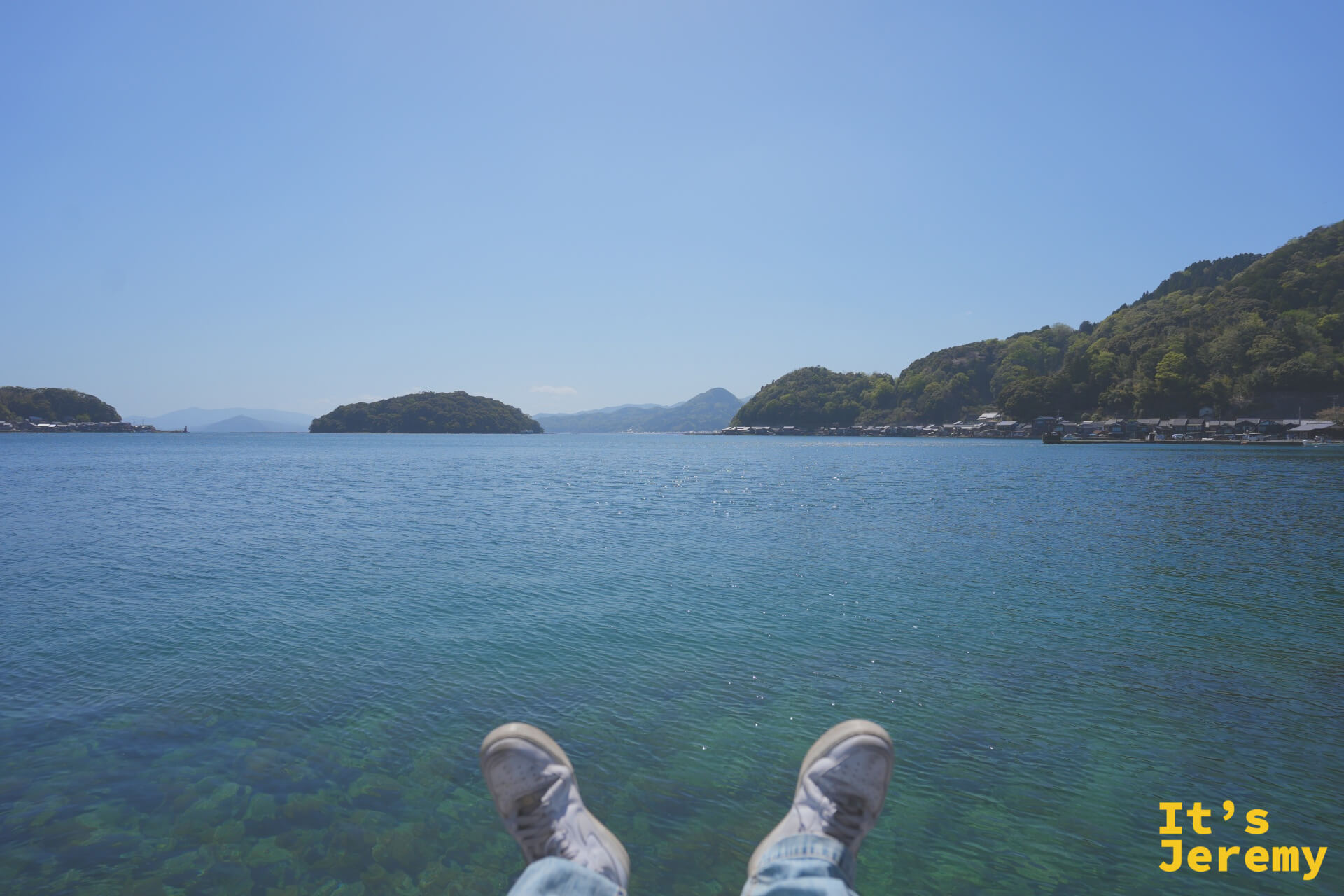 伊根湾に足を投げ出して座る