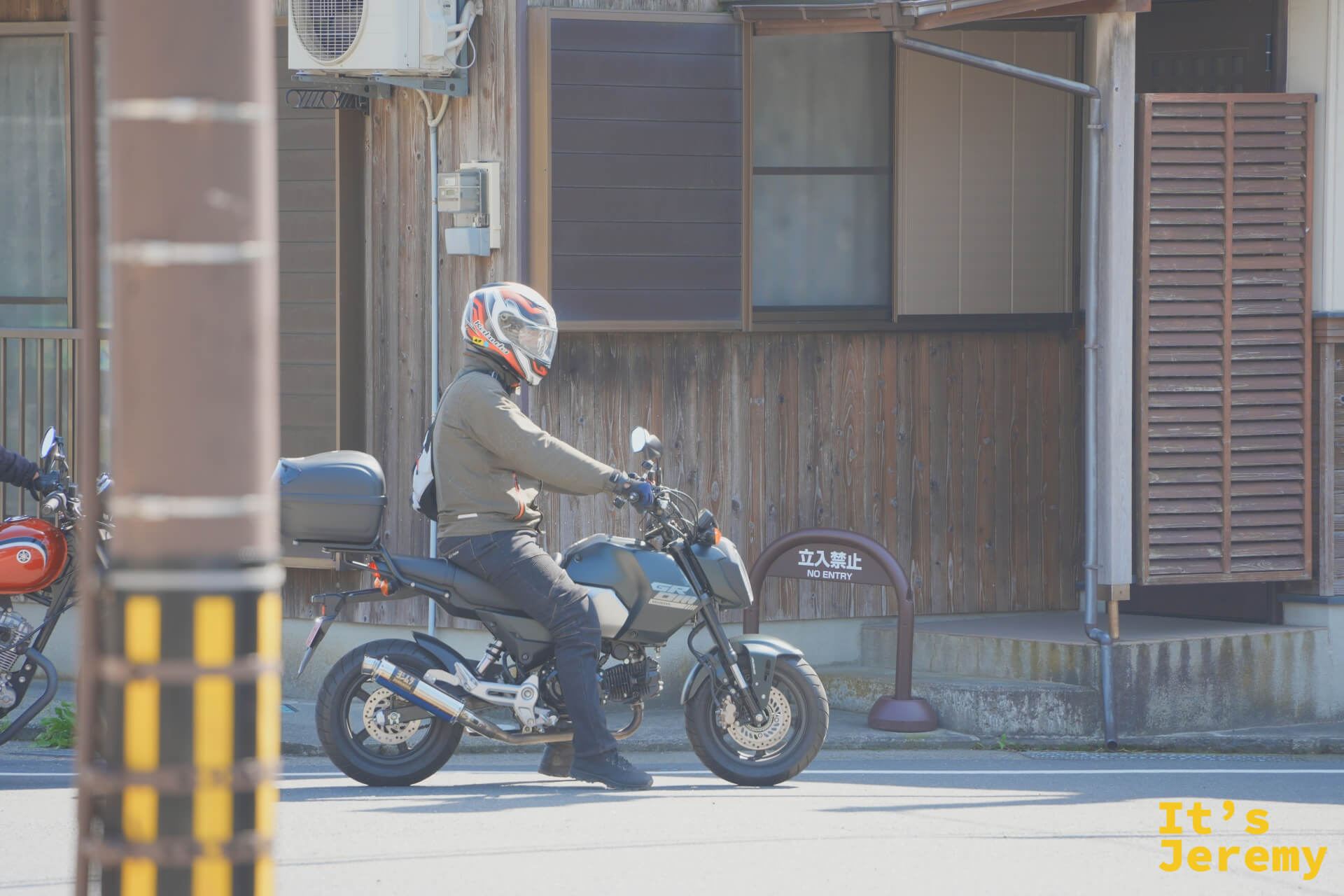 伊根の舟屋の前をバイクが走る