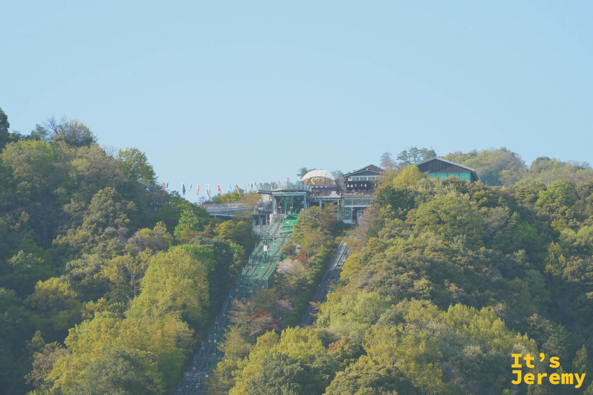 船上から傘松公園の山とリフトを望む