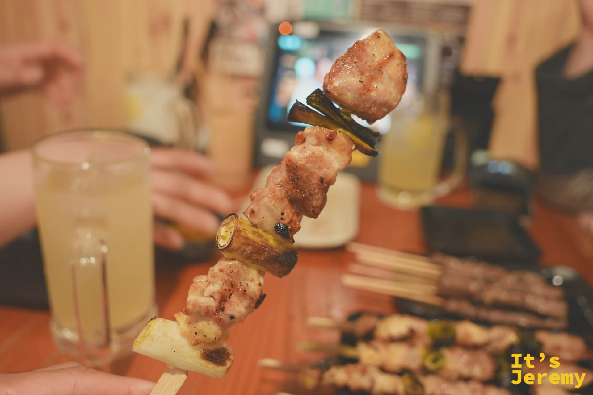 もも串を高く掲げる(ネギ挟み)