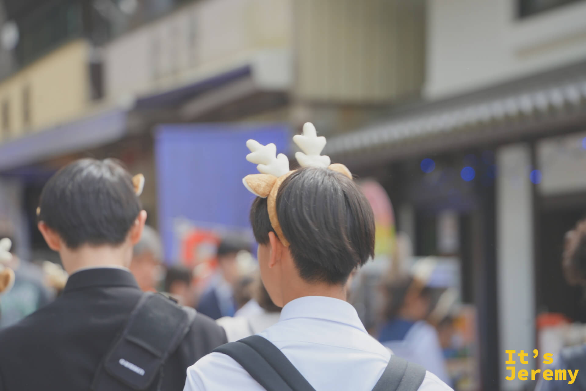 穿制服的學生戴著鹿角造型髮箍走在奈良商店街