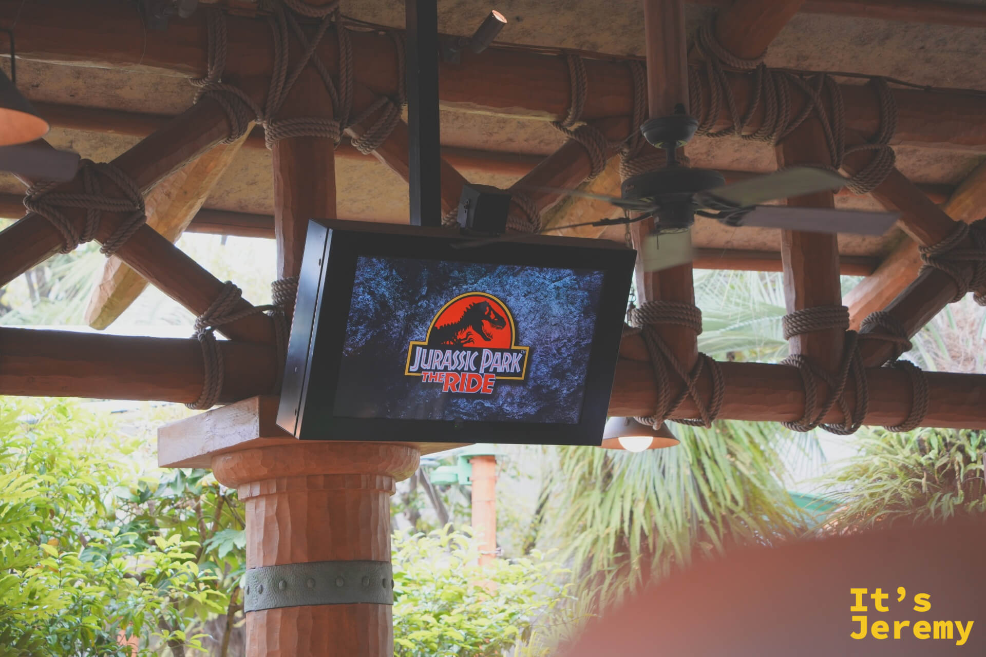 Jurassic Park The Ride 的懸掛式電視，LOGO 字樣在熱帶木構架下格外有氣氛