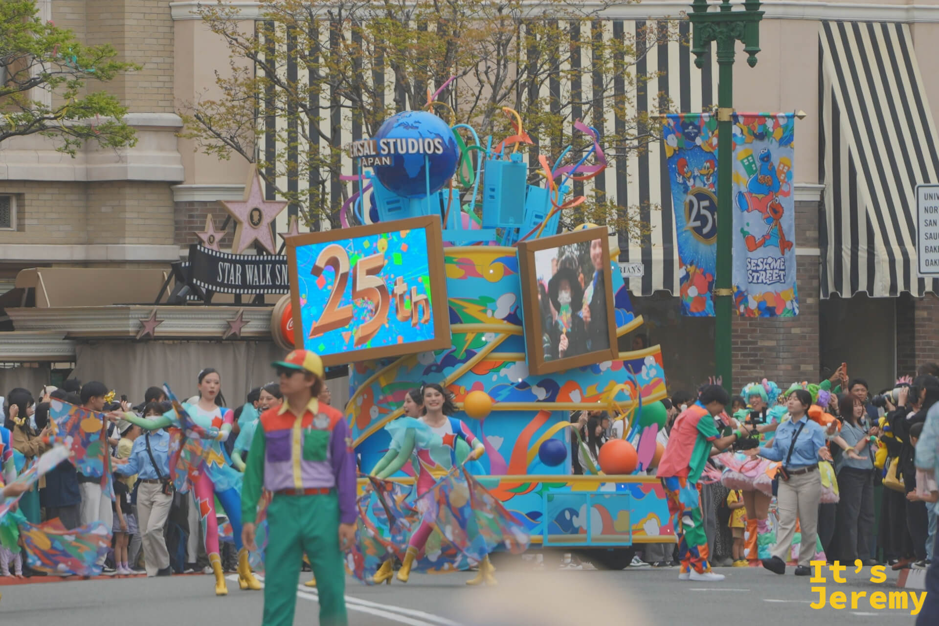 25th Anniversary 開場花車，藍色車體上掛著電視螢幕播放週年慶影像，演員圍繞花車起舞