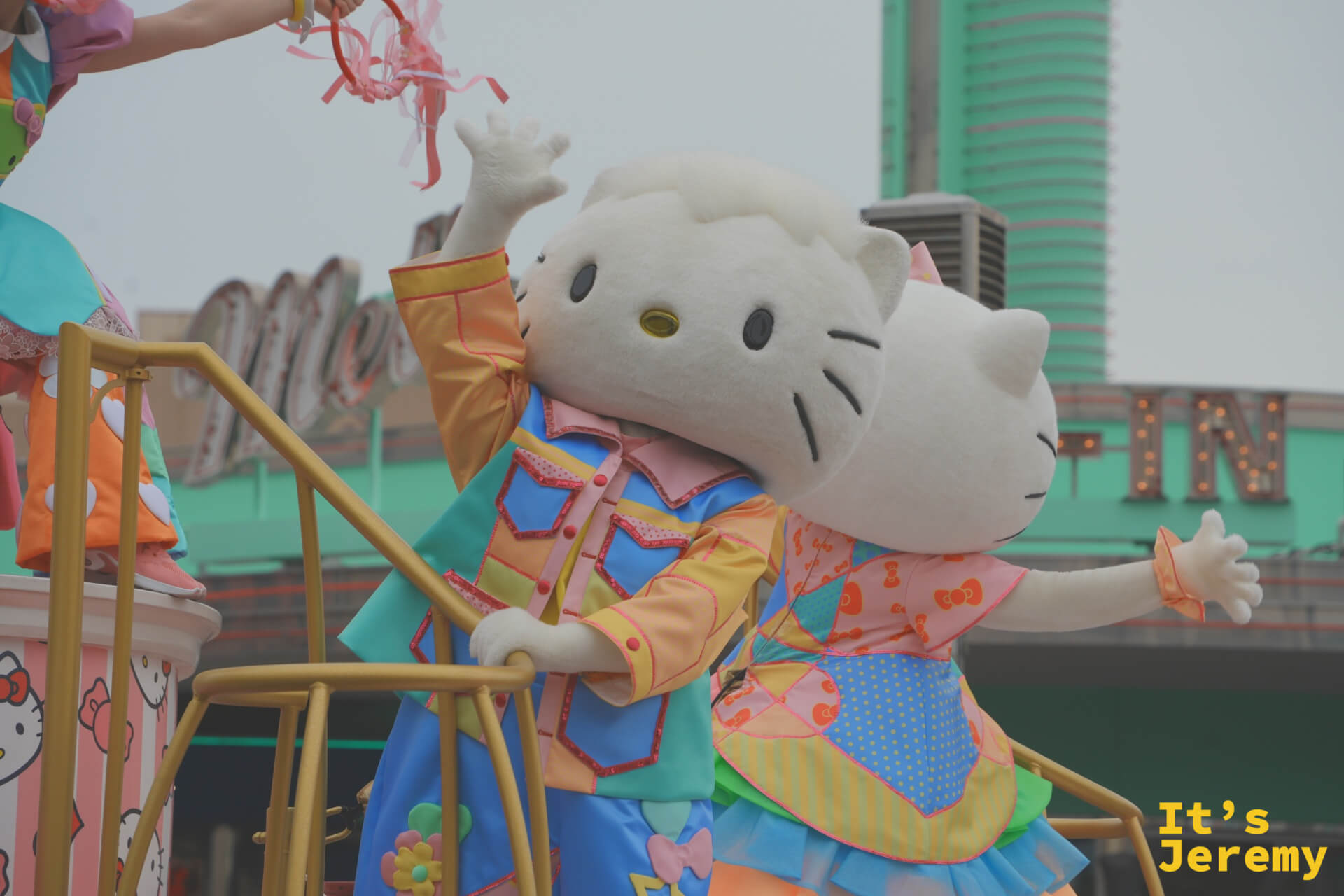 Hello Kitty 與 Dear Daniel 緊靠在一起向觀眾招手，兩人的服裝是 25 週年限定款花衫設計