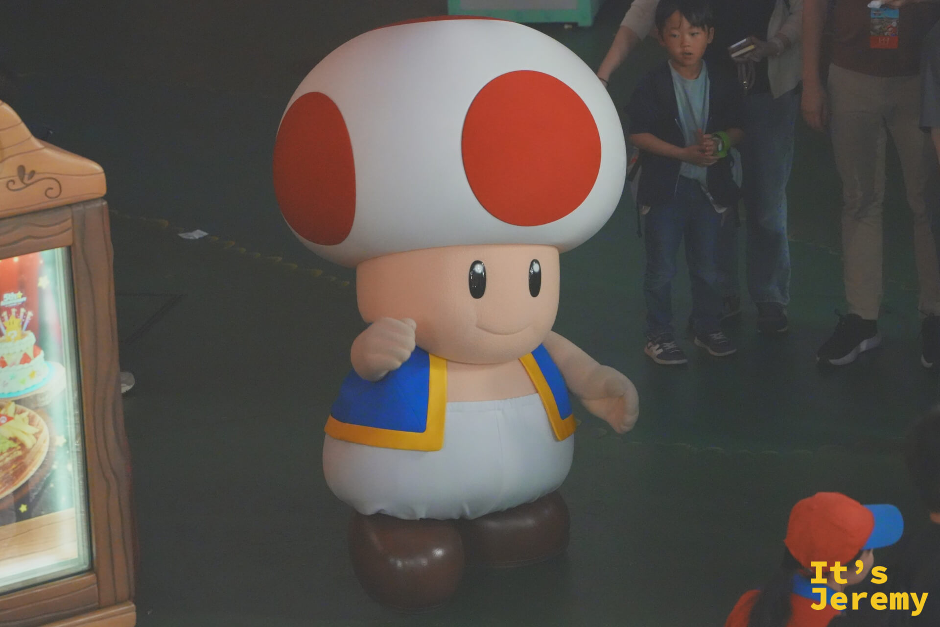 Toad（奇諾比奧）真人角色，正在 SNW 內部與遊客互動，白底紅點的蘑菇帽格外顯眼