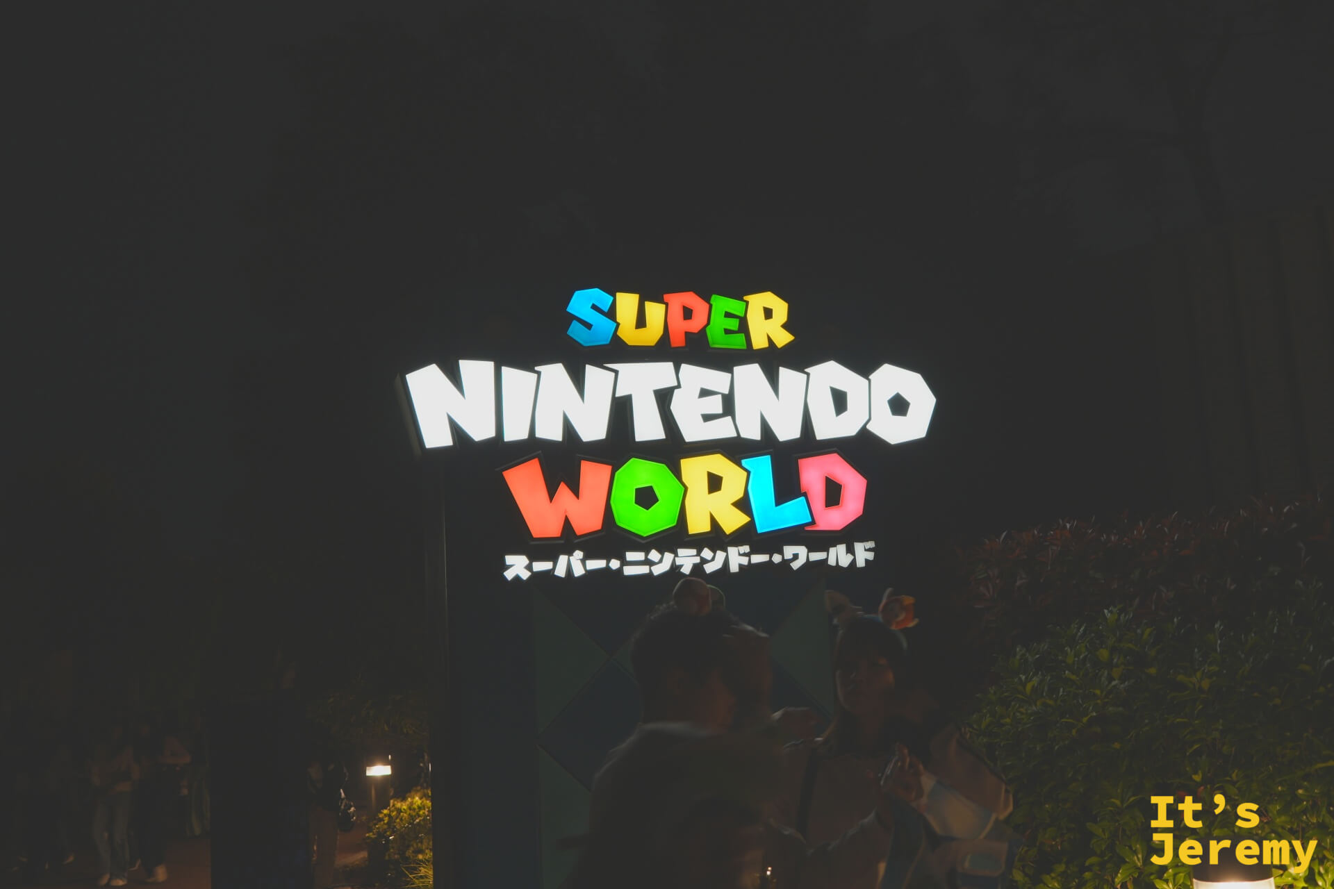 SNW 霓虹招牌特寫，「SUPER NINTENDO WORLD」的日文假名「スーパー・ニンテンドー・ワールド」在夜色中發著七彩光