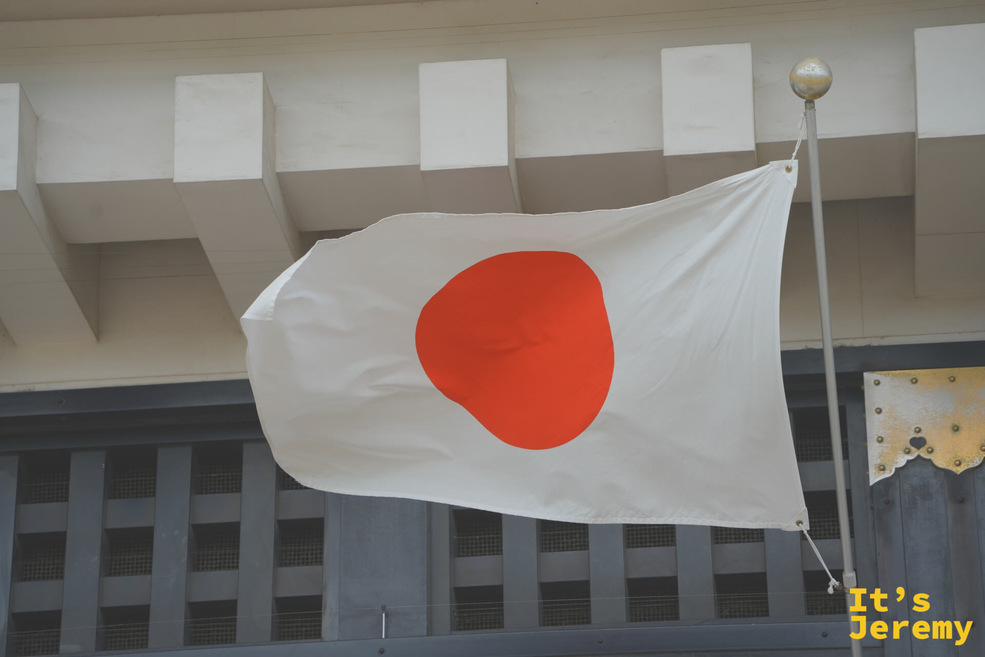 城牆石壁前的日本國旗，旗面在天空中展開